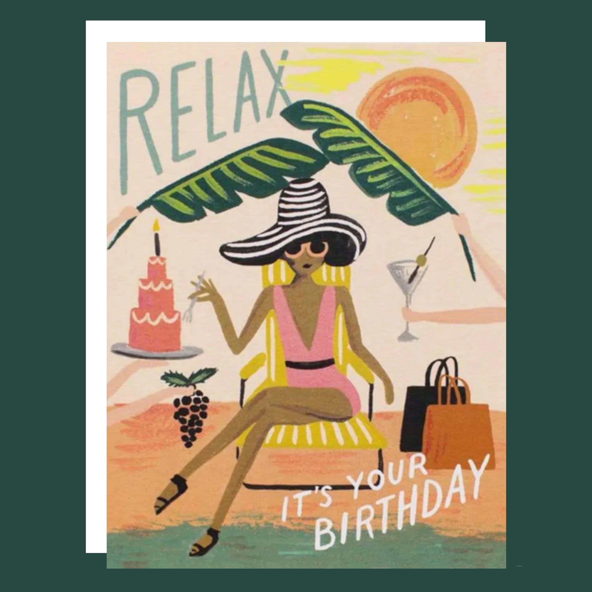 a card with a drawing of a woman in a pink bathing suit sitting on a yellow lounge chair. She is wearing a large white and black striped hat. To the left of her is a hand holding a tray with a three tiered pink cake. To the right is a hand holding a martini. There are two large leaves above her. On the top right corner is blue text that reads ‘relax.’ On the bottom right is white text that reads ‘its your birthday.'