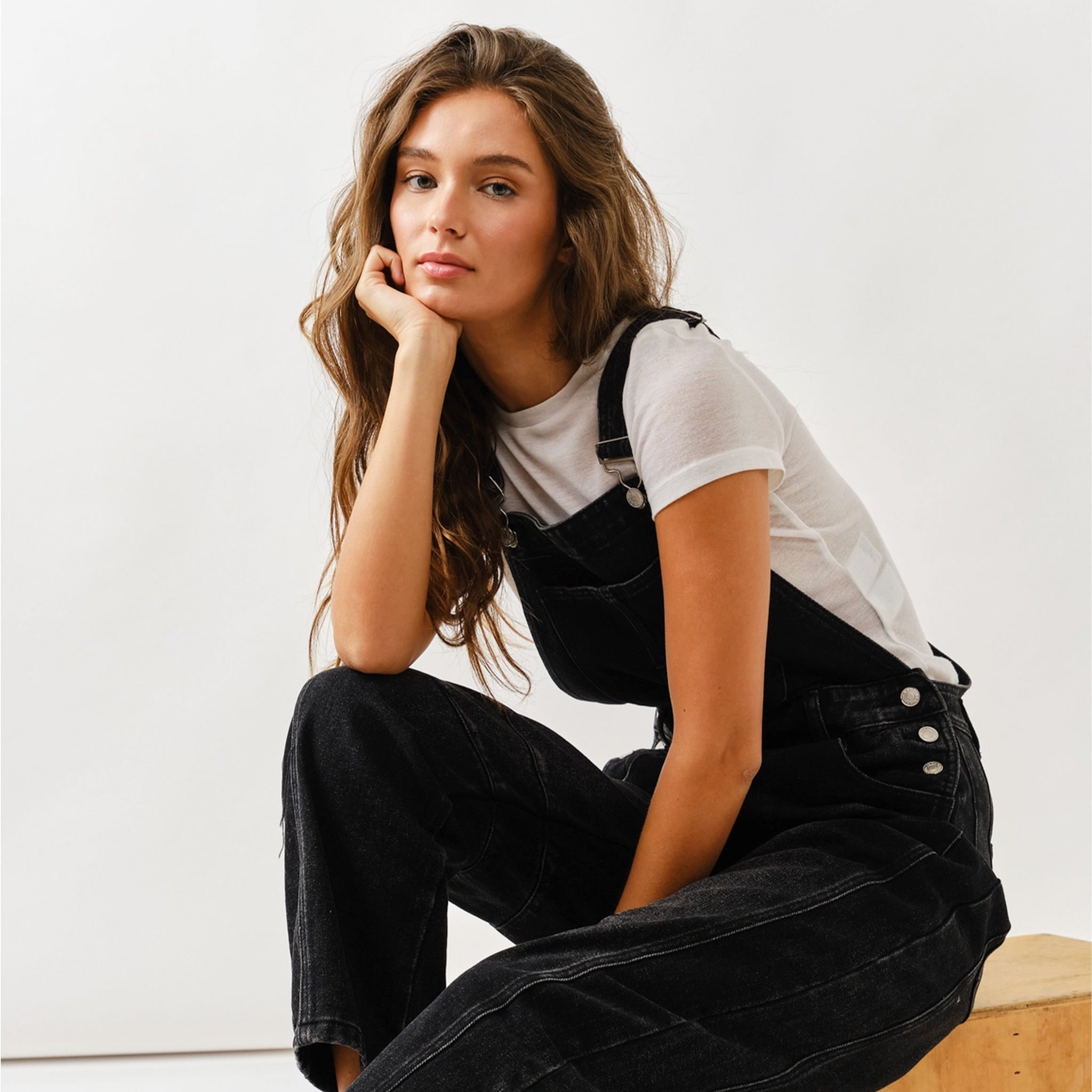 A black pair of denim slouchy overalls. 