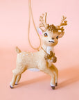 A reindeer shaped ornament in a beige color. 