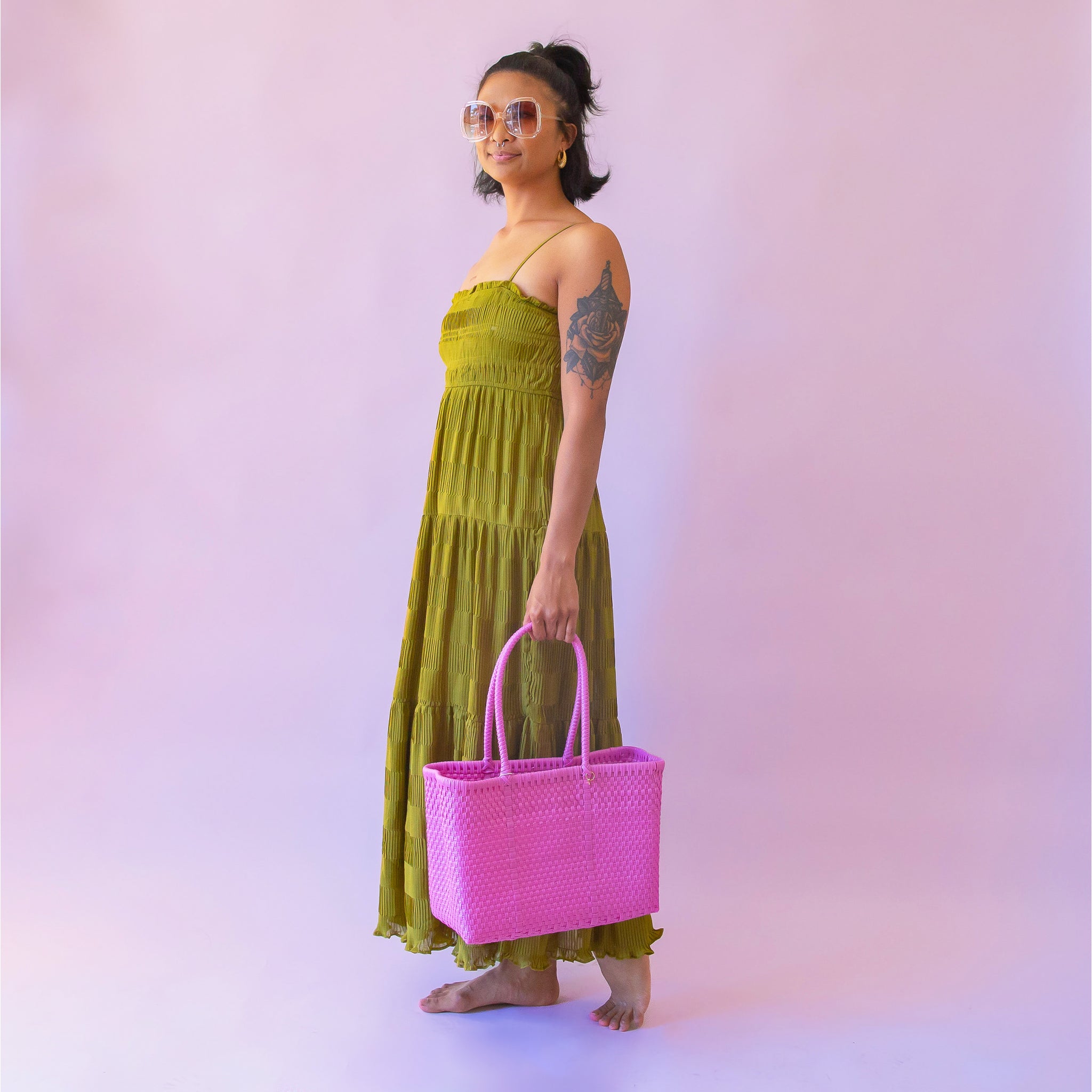 On a pink background is a hot pink woven bag.