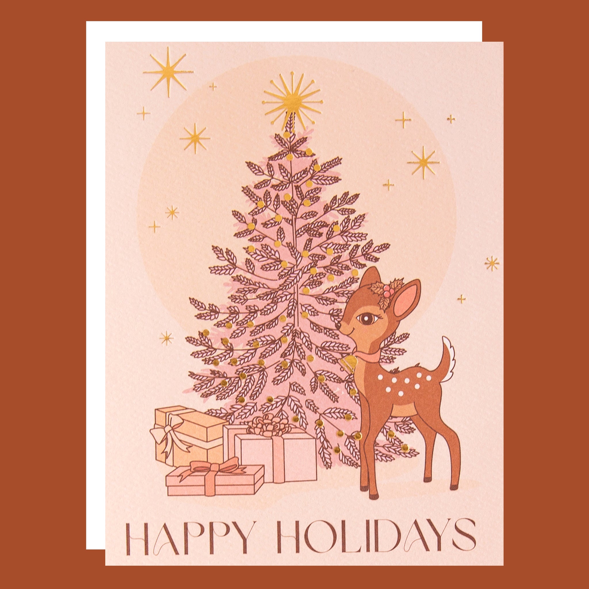 On a pink background is a soft pink greeting card with a Christmas tree and retro deer illustration not he front along with text along the bottom that reads, "Happy Holidays".