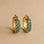 A gold pair of hoop earrings with turquoise stones. 