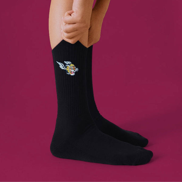 A black pair of crew socks with a tiger with a wing helmet graphic on the side. 
