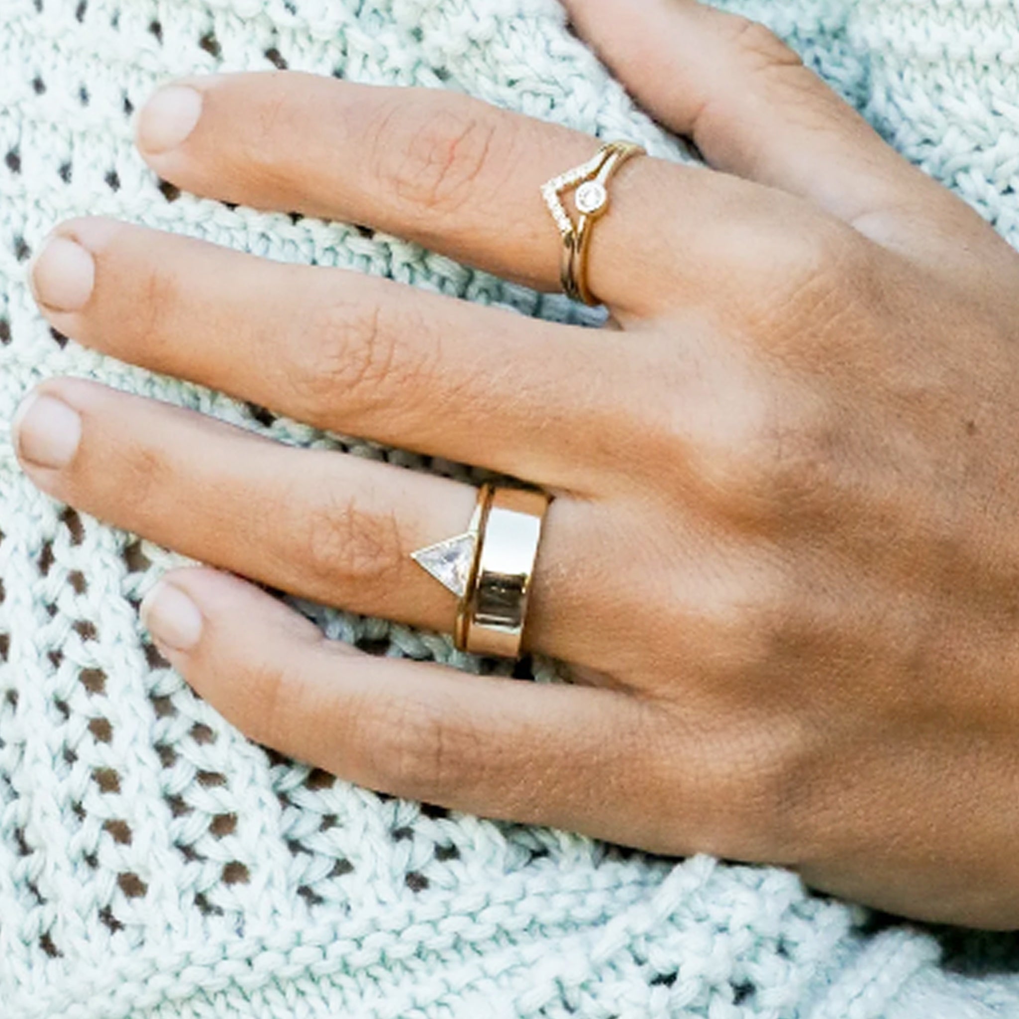 A gold ring with a triangle CZ stone in the center.