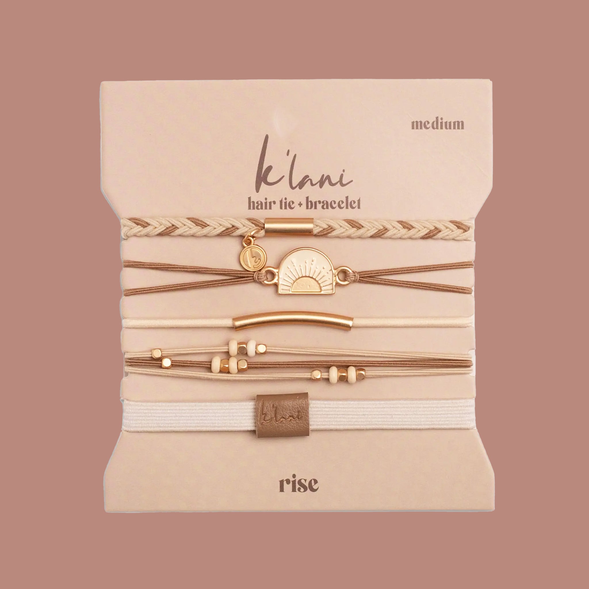 A set of five bohemian-style hair ties and bracelets displayed on a beige backing card. The set includes braided elastic bands, thin brown cords, a gold-tone sun charm, and small bead accents.