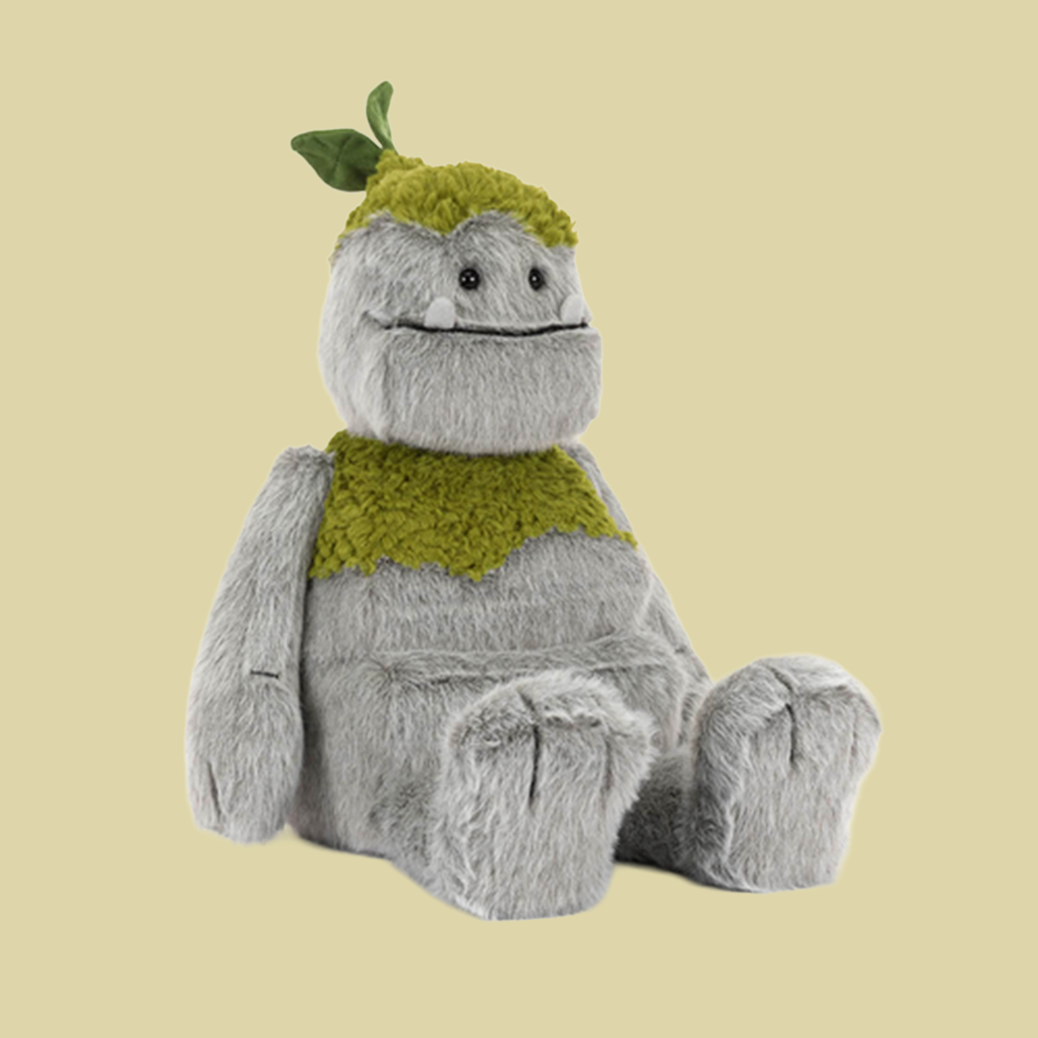 Soft plush forest creature with fuzzy gray fur, moss-green accents, a sweet smile, and a tiny leaf on its head.