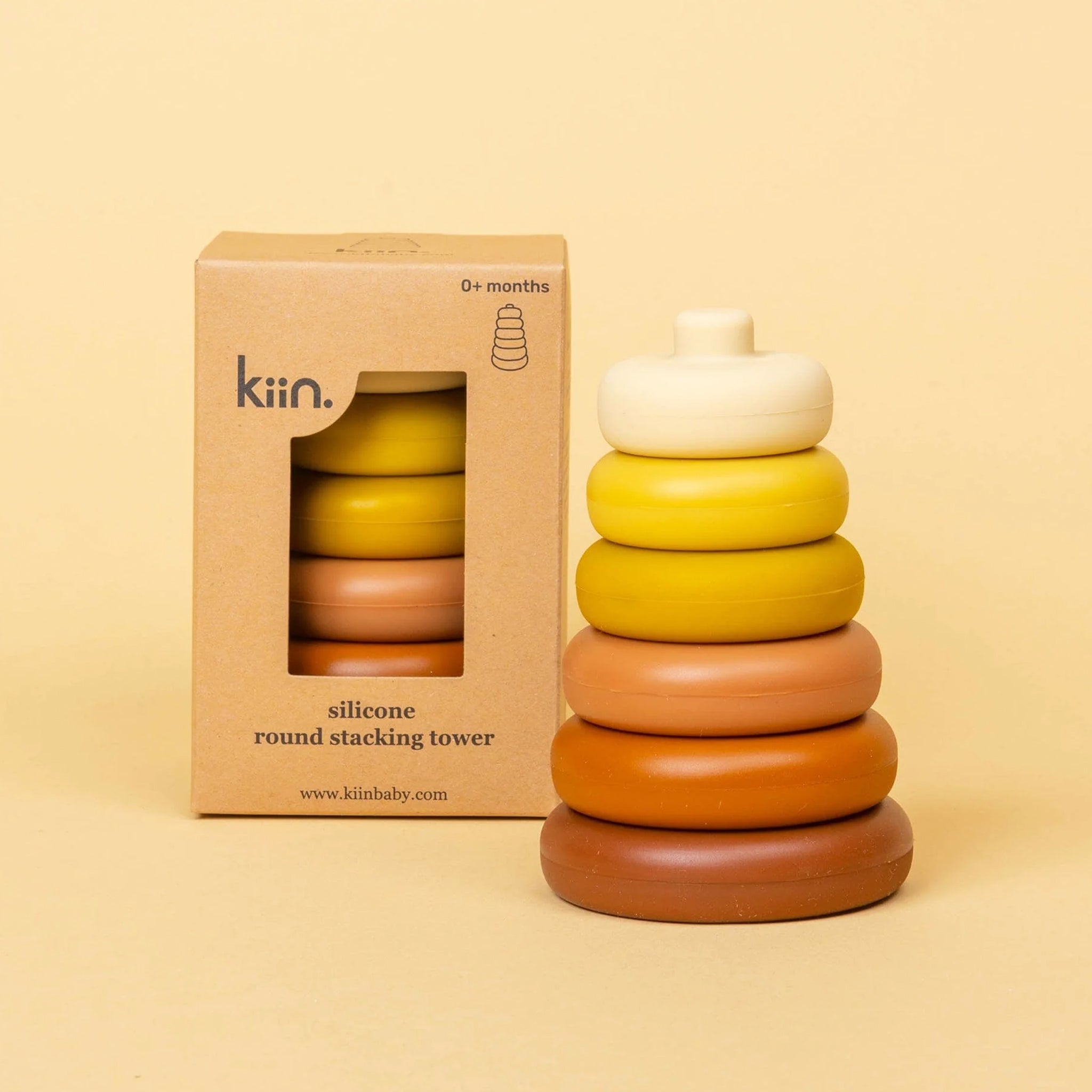 A children's silicone stacking toy in shades of yellow, orange and burnt orange.