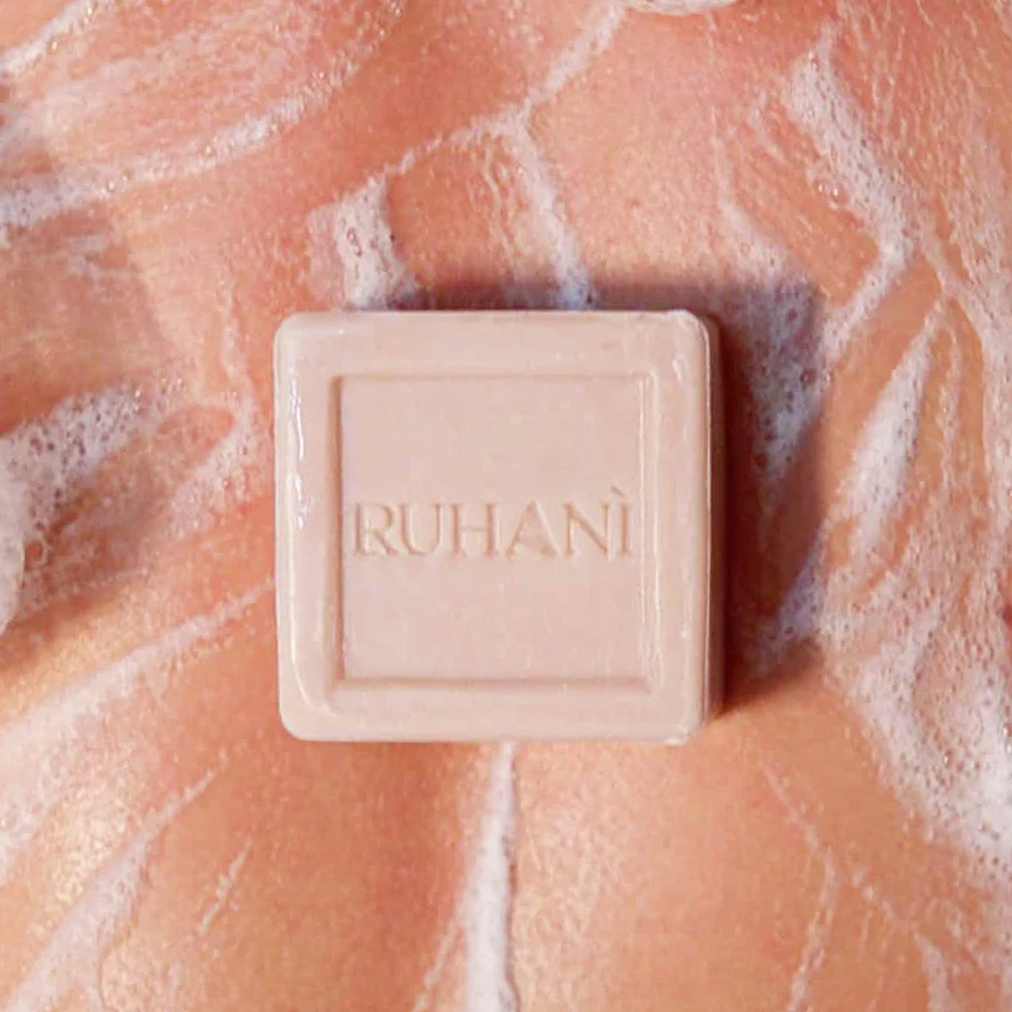 A square bar of soap etched with text that reads, "Ruhani". 