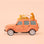 Peach safari car ornament with two cheetahs perched on the roof of the car. 