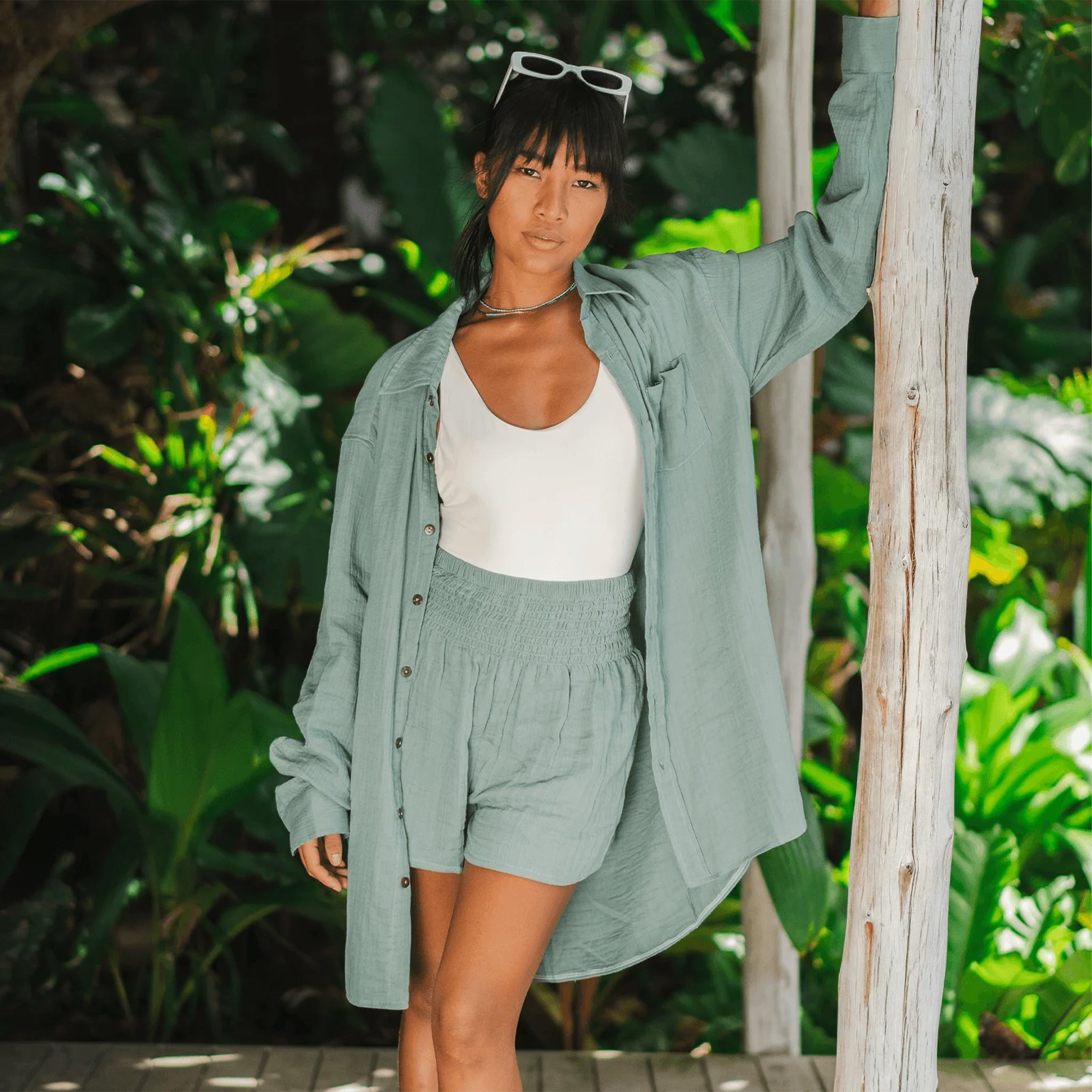 Woman in a green outfit standing in a tropical setting