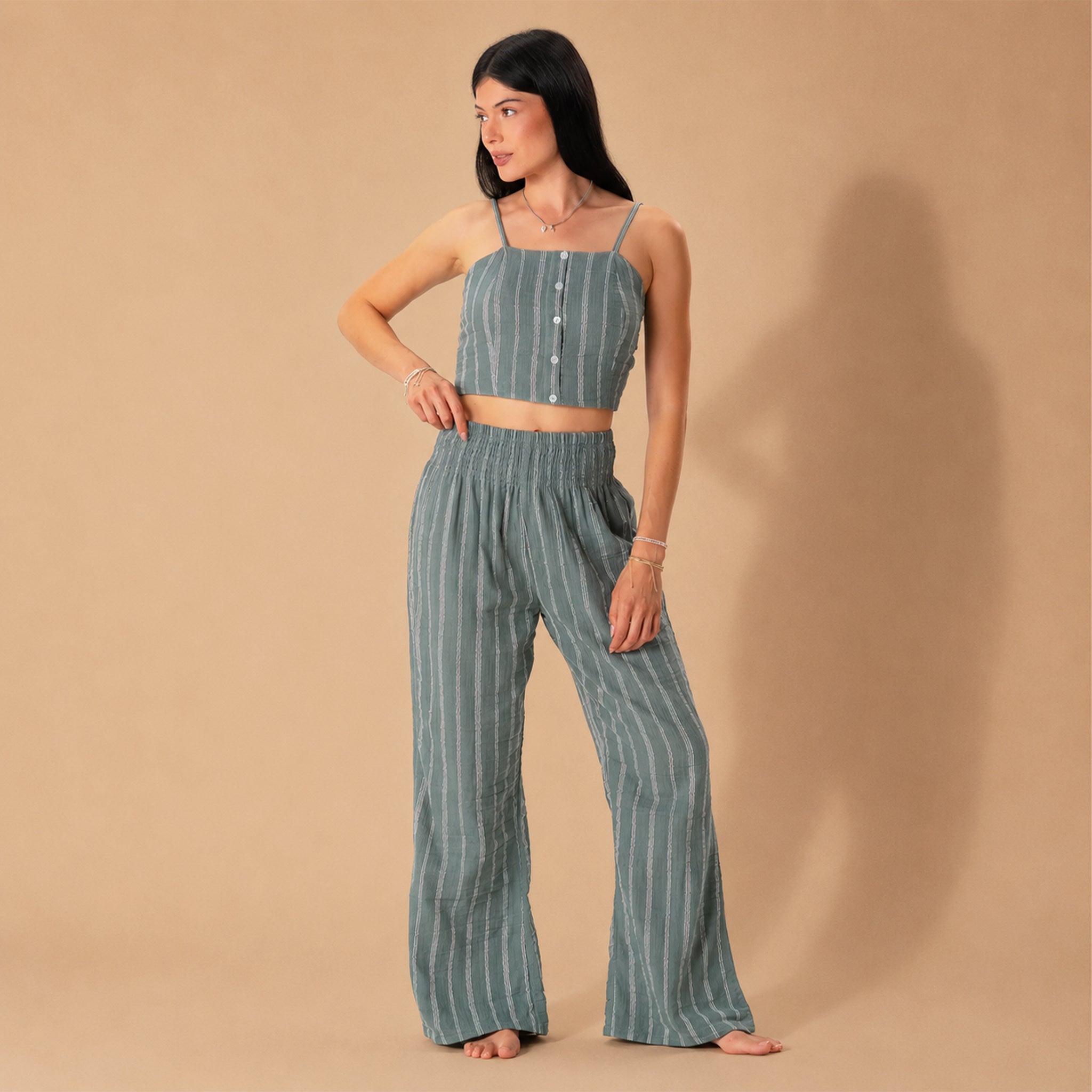 A model wearing a pair of sage striped pants. 