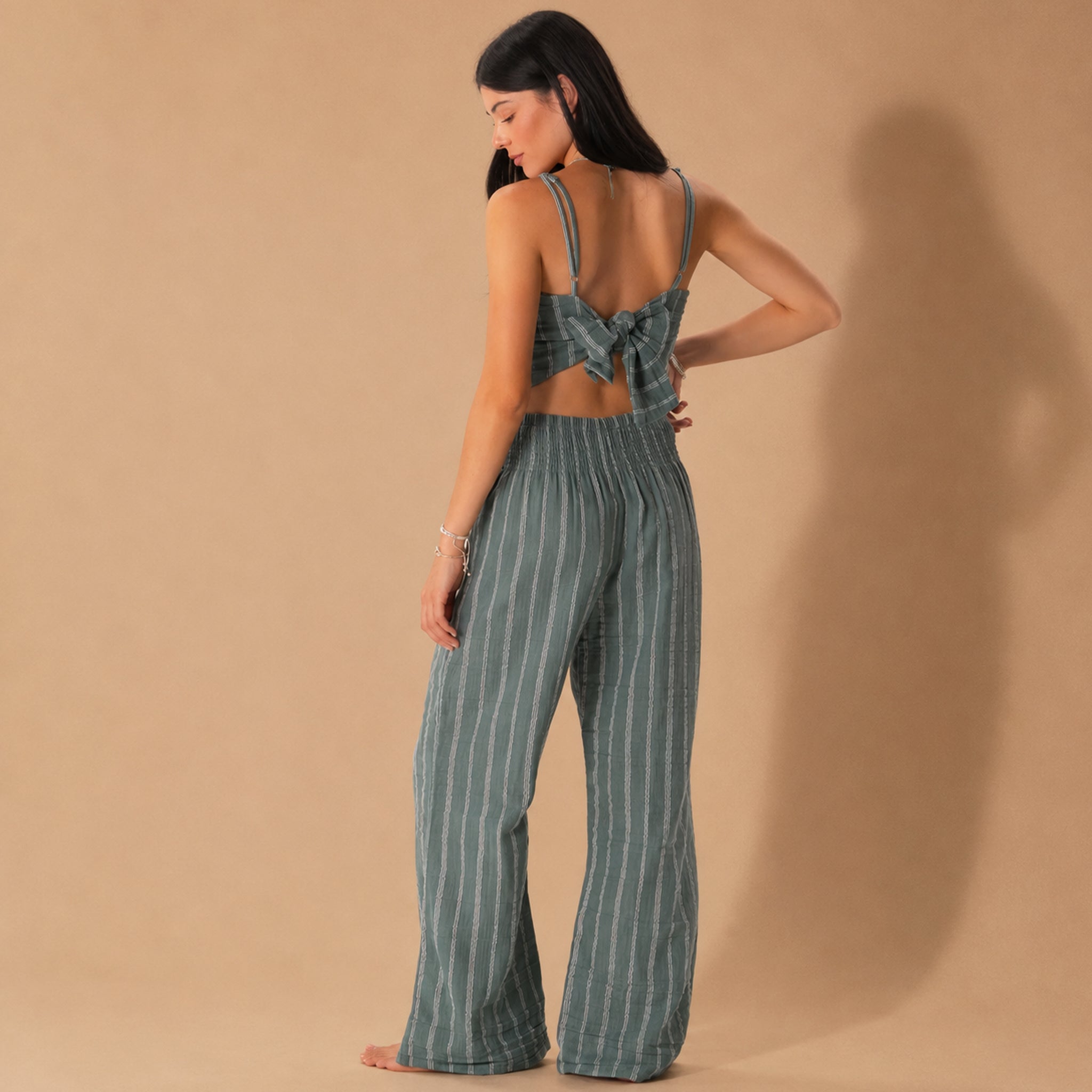 A model wearing a pair of sage striped pants. 