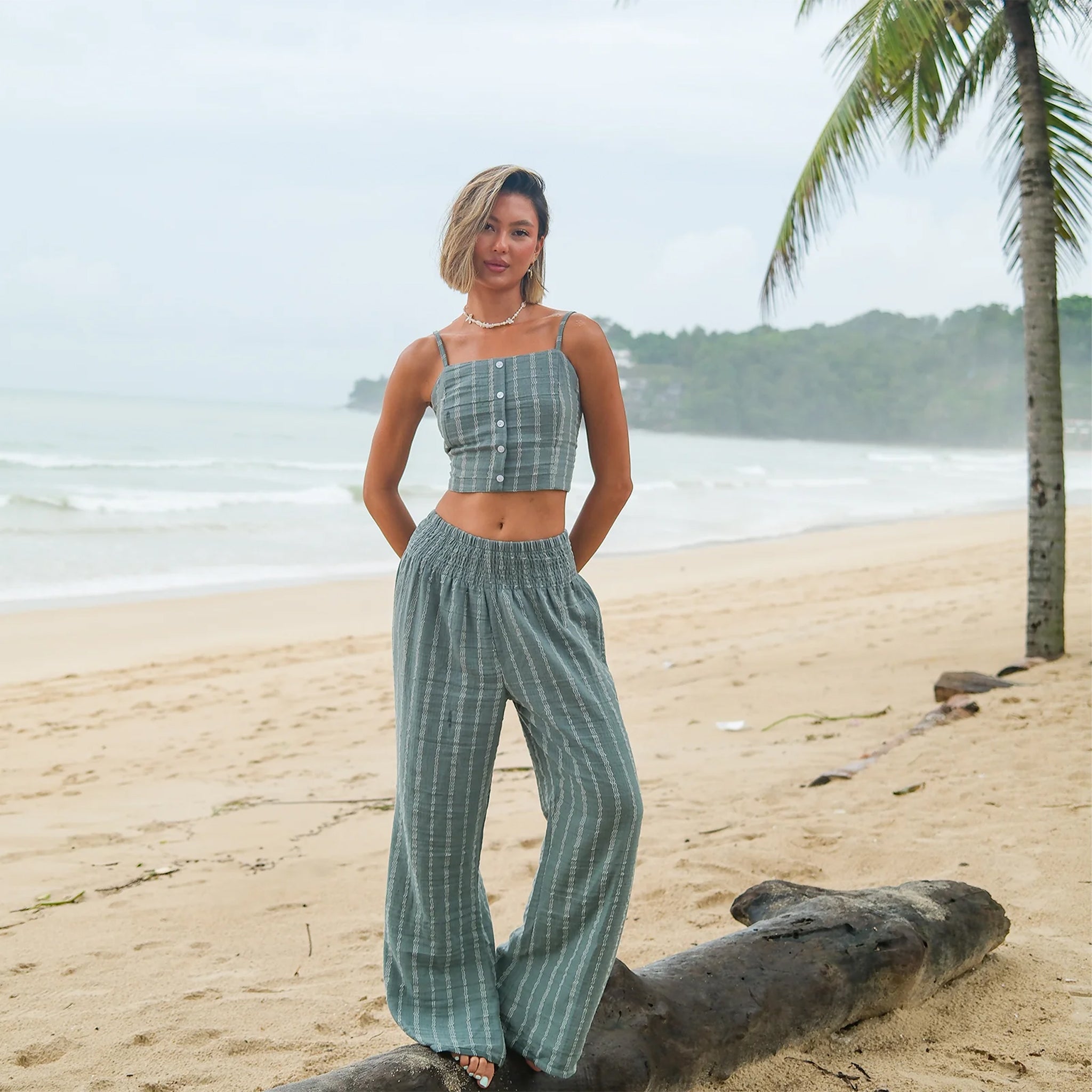 A model wearing a pair of sage striped pants. 