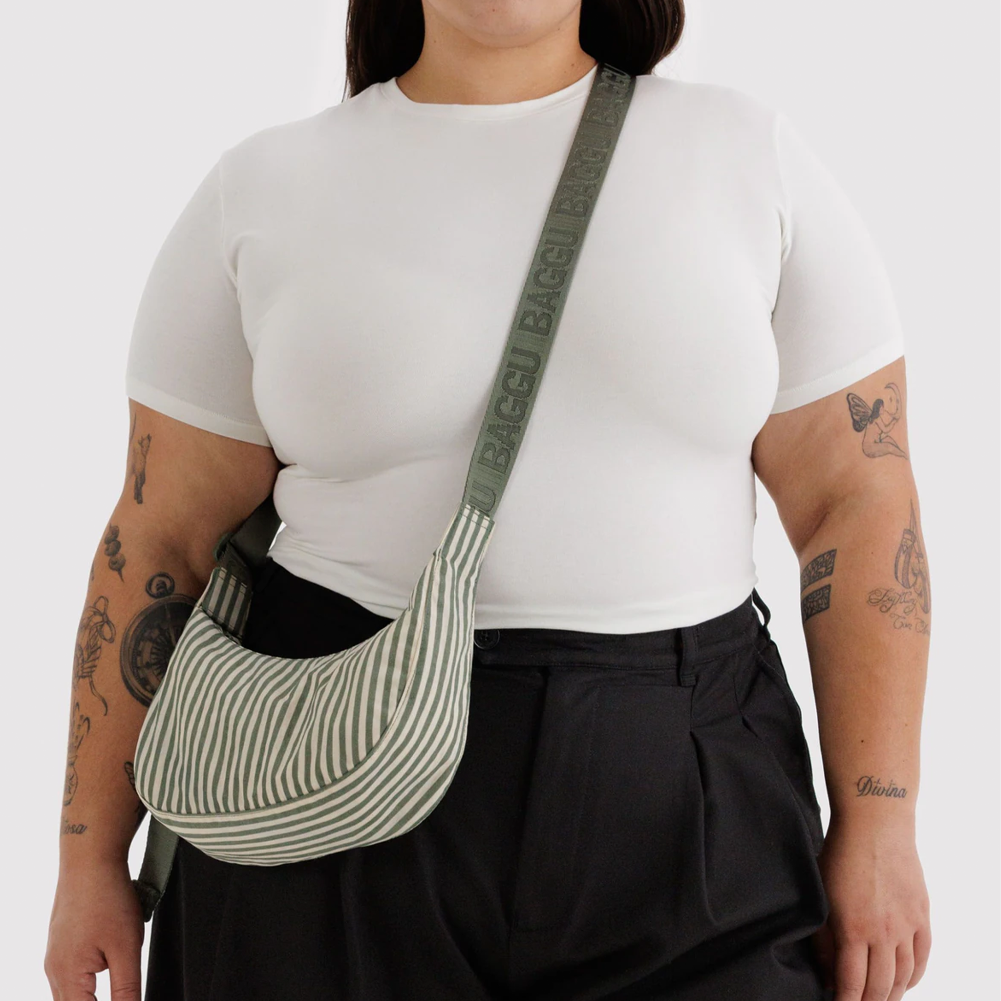 sage striped nylon purse with sage colored strap on a model.