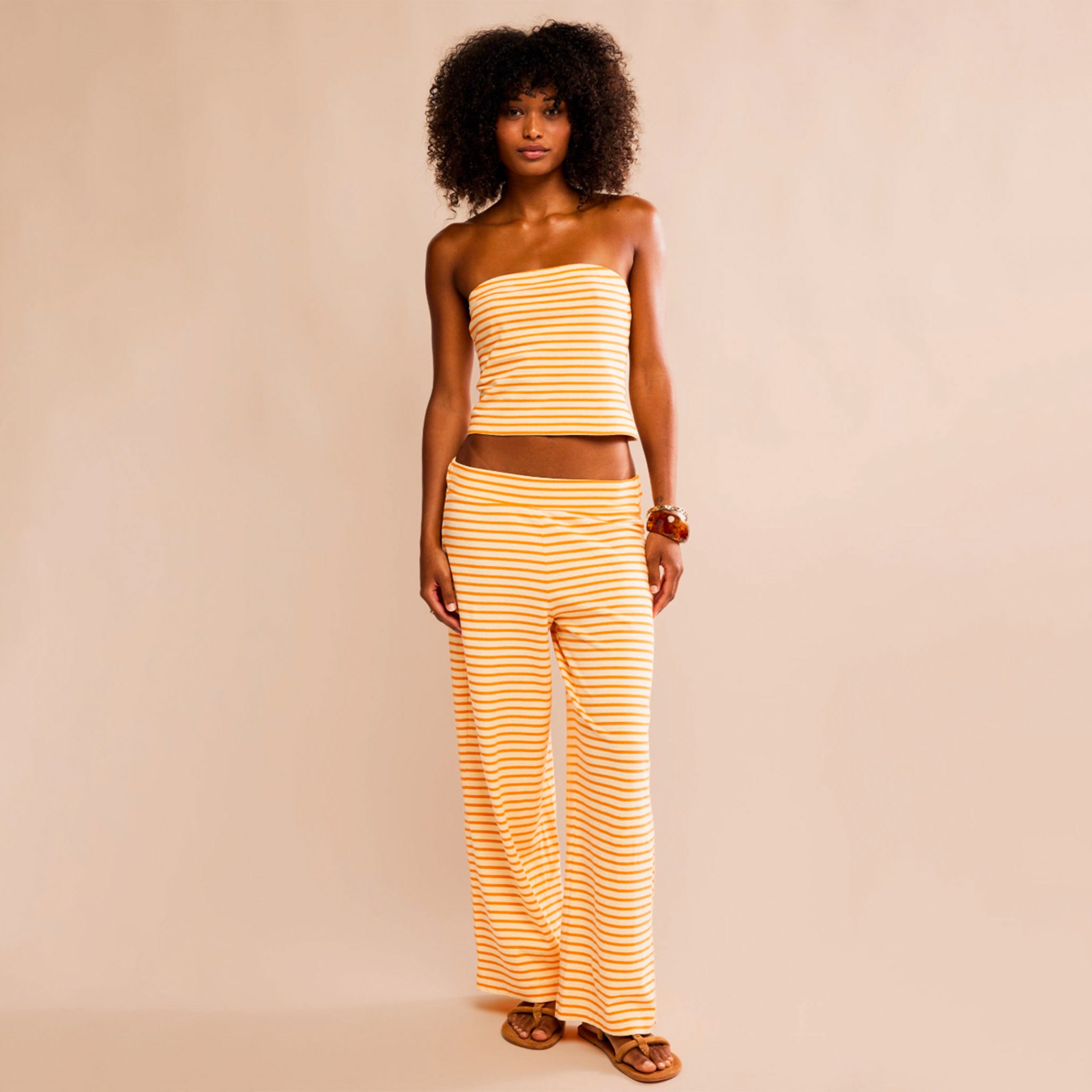 A yellow and range striped tube top and pant set. 