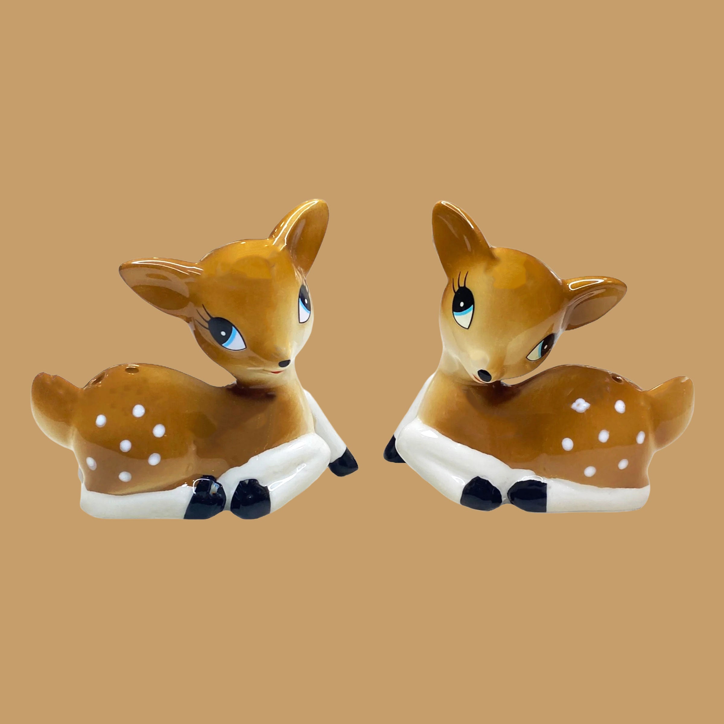 A white mouse shaped ornament wearing a bowtie and fuzzy pants. 