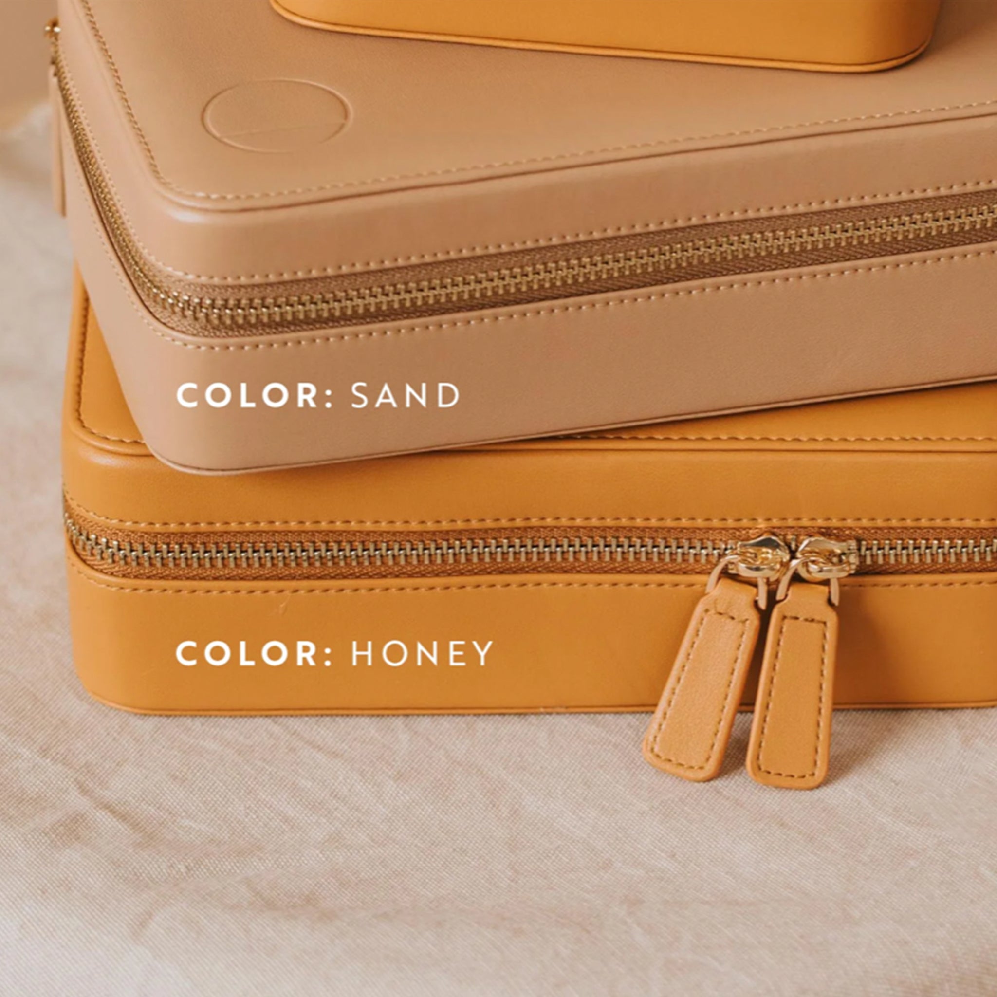 The sand travel jewelry case with a double zipper on top of a different colored case