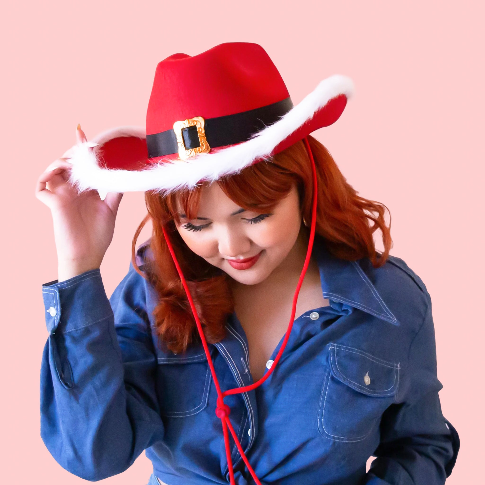 A cowboy hat with a "Santa Hat" design and a neck strap. 