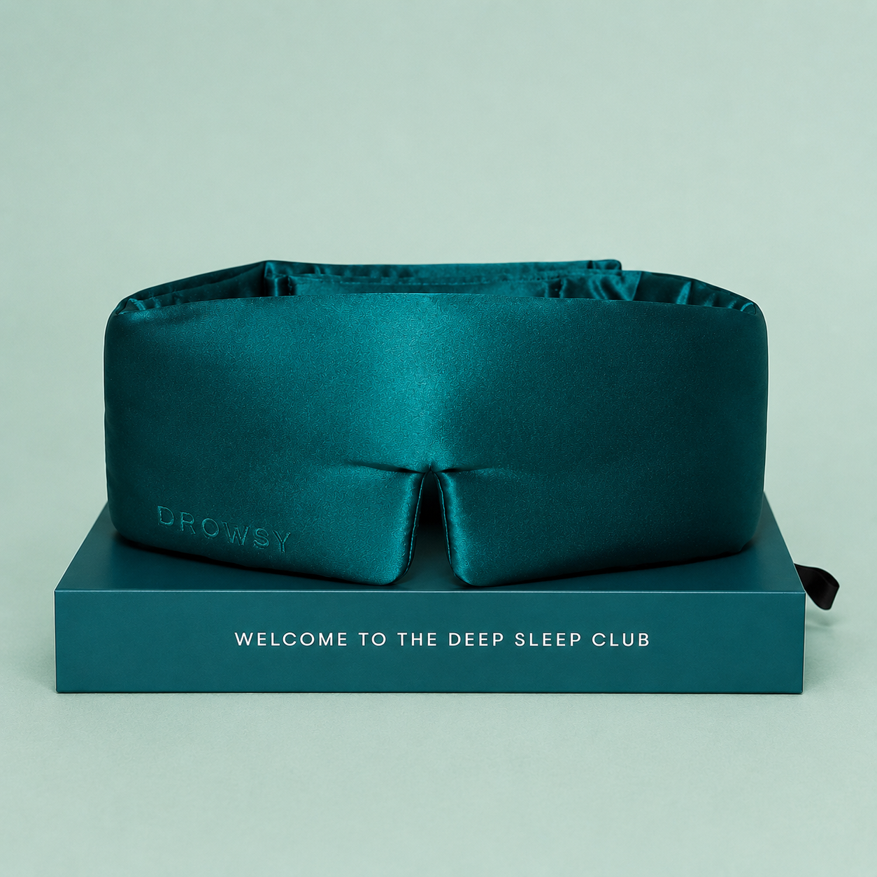 a sapphire green padded sleep mask. 