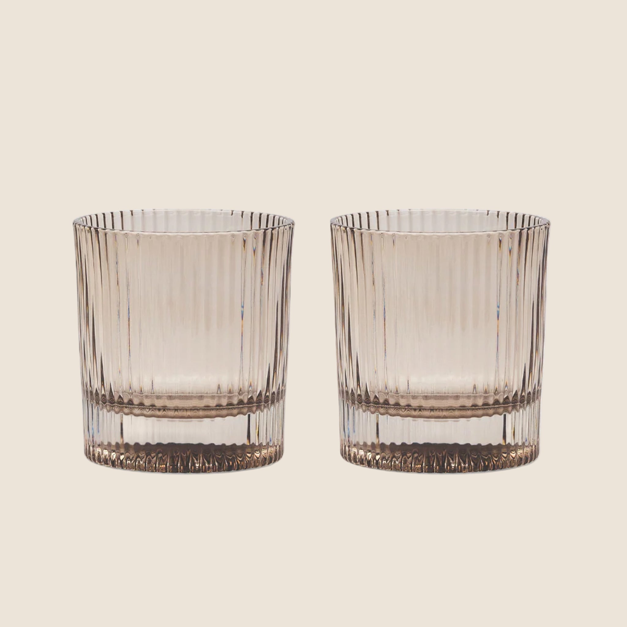 A set of lowball ribbed cocktail glasses in a smoke grey shade. 