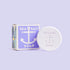 Sea salt bar soap with anchor design beside its packaging, shown on a soft lavender background.