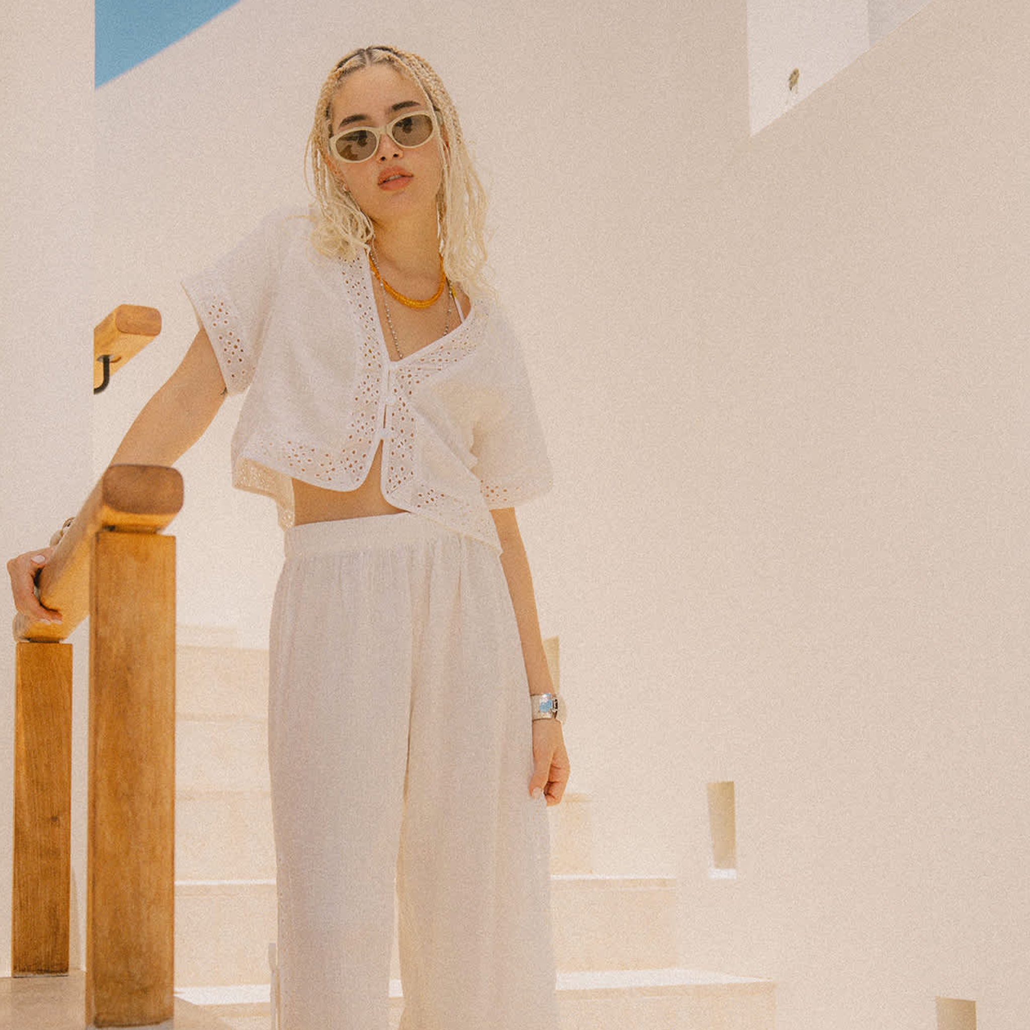 A short sleeve eyelet sleeve and neckline white crop top button up. 