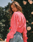 A model wearing a pink sequin cropped sweater. 