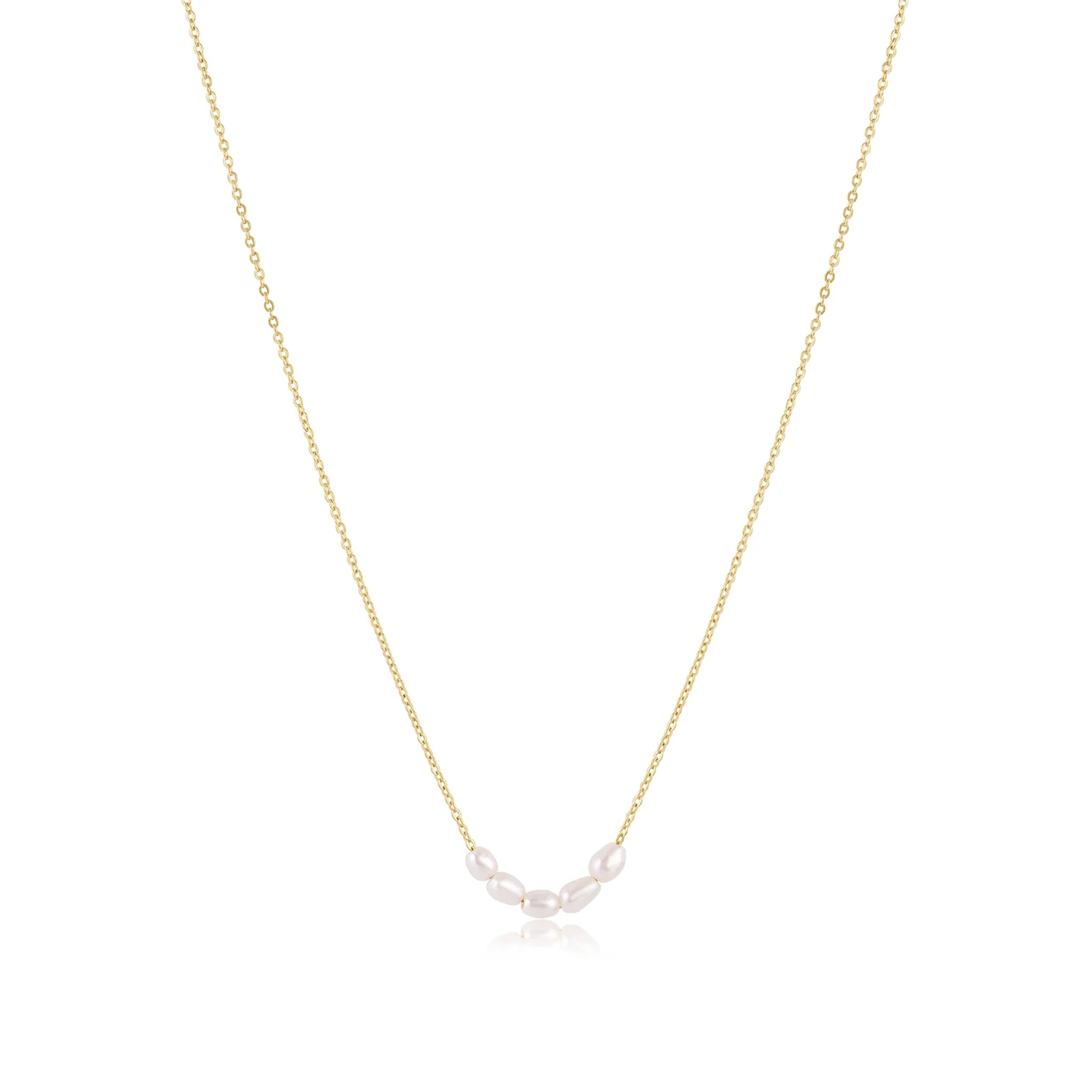 The dainty gold chain necklace with five small pearls lined next to each other.