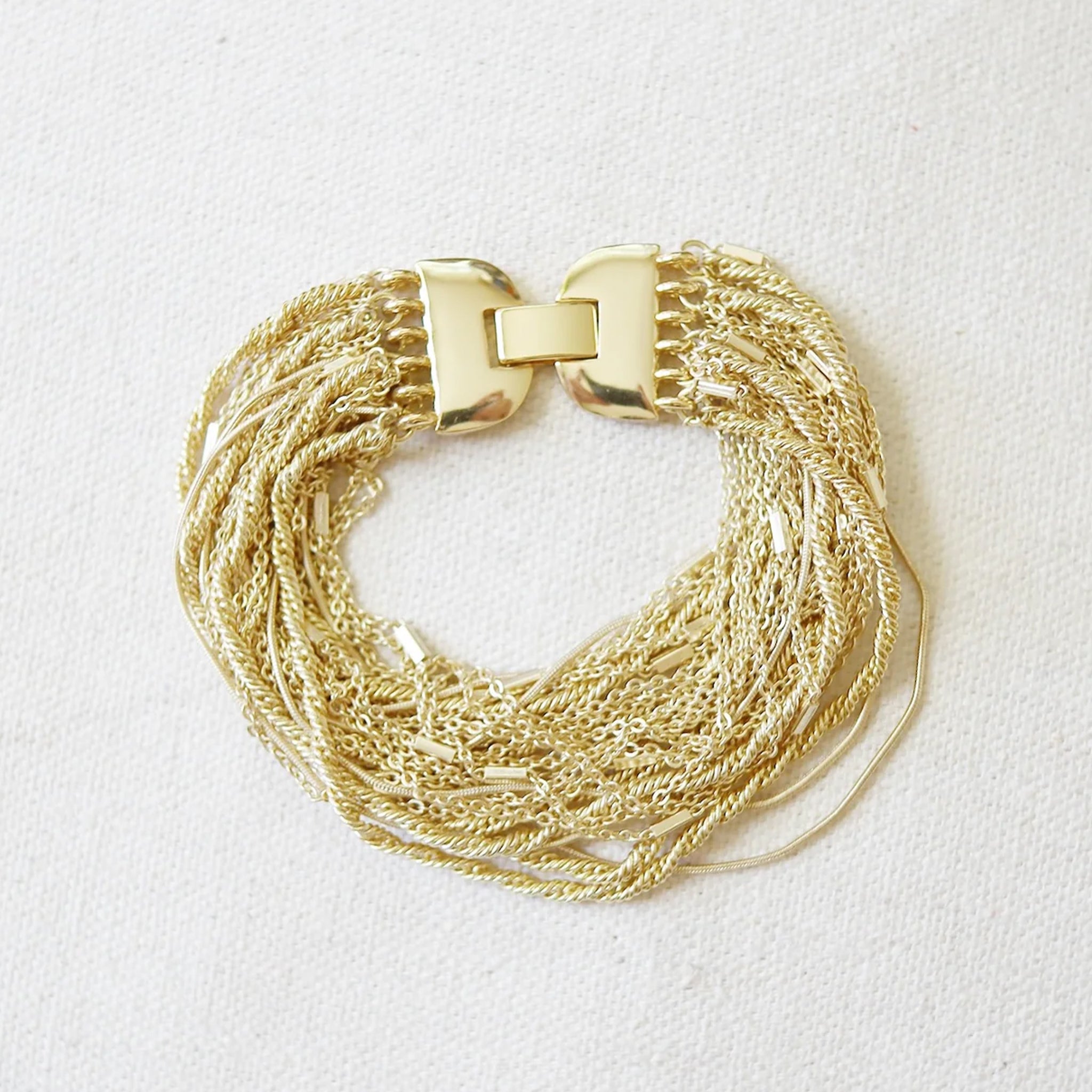 Small thin chains made into one thick bracelet with a conjoining clasp. 