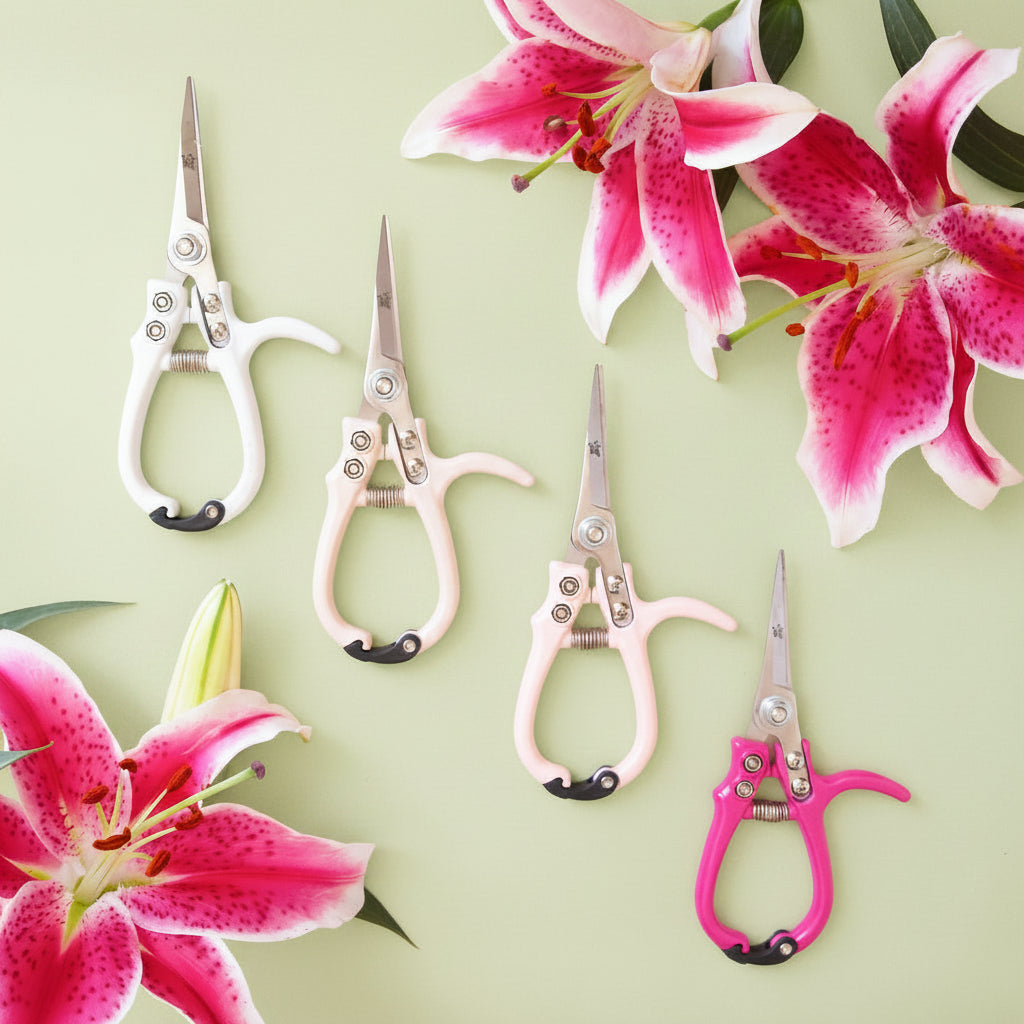 On a green background is the four color ways of pruning shears next to bouquets of flowers.