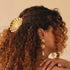 A gold shell shaped hair clip. 