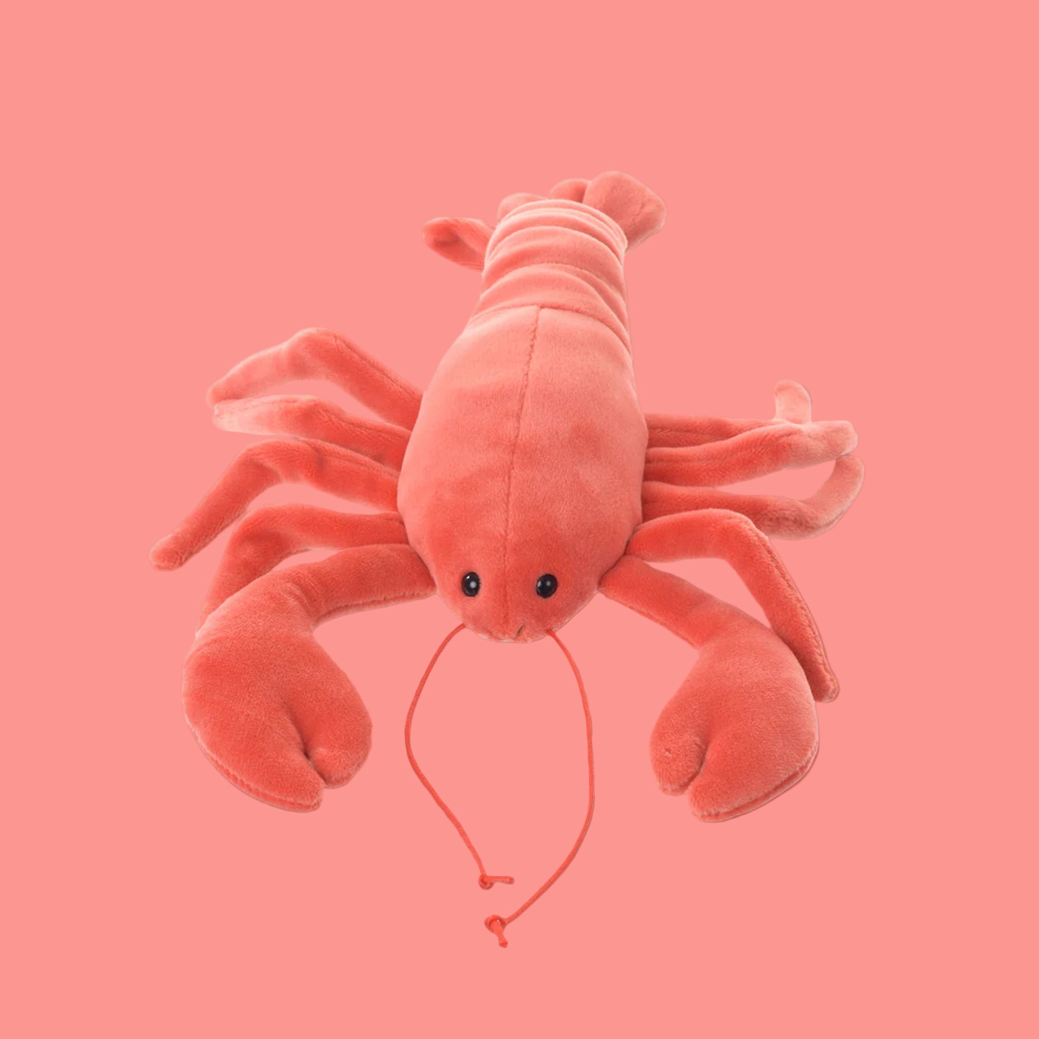 A coral colored lobster shaped stuffed toy. 