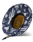 A straw sun hat with a dark blue and white desert design under the brim and a coordinating neck strap.