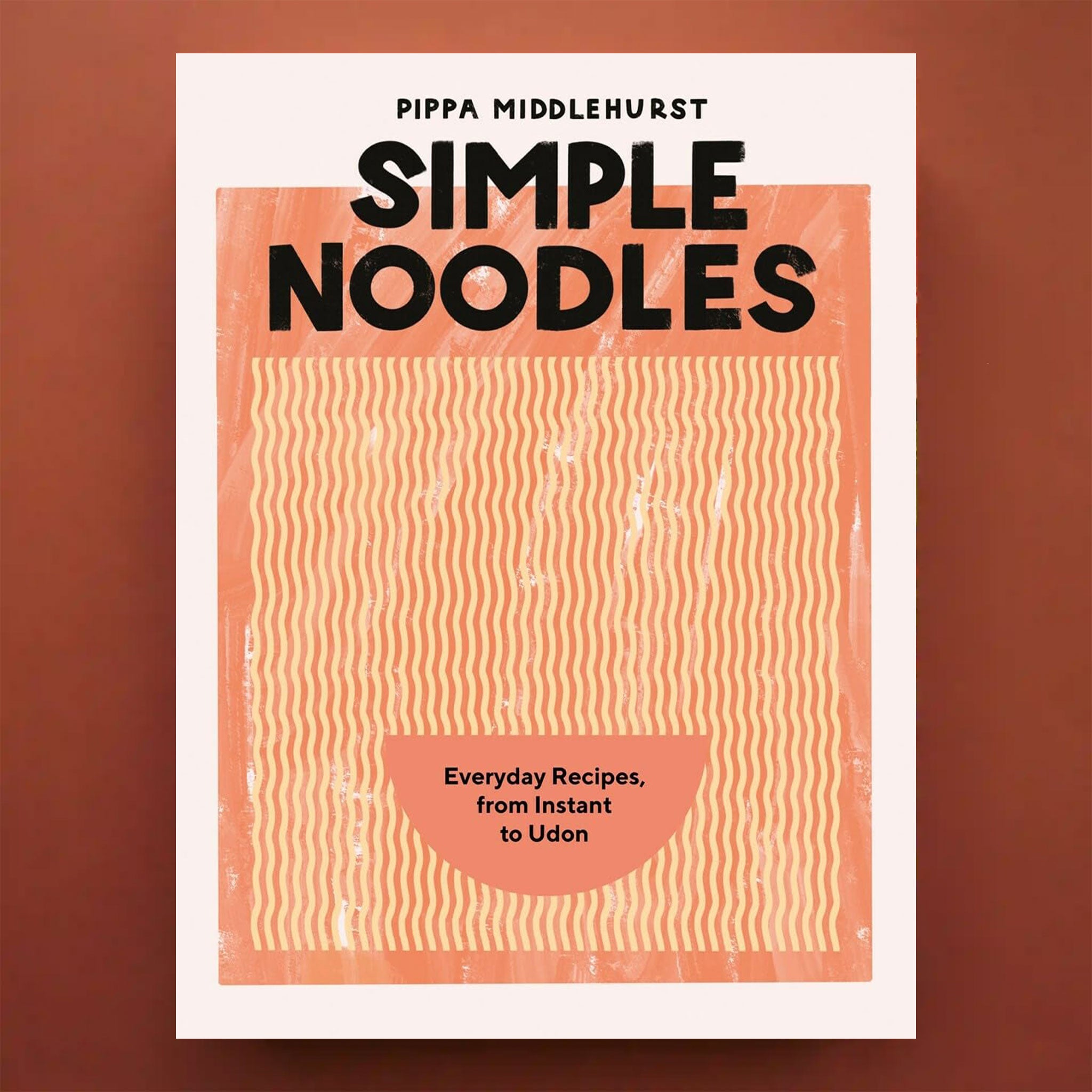 On a brown background is a orange and yellow book cover with a graphic of a bowl of ramen along with black text at the top that reads, &quot;Simple Noodles&quot;.