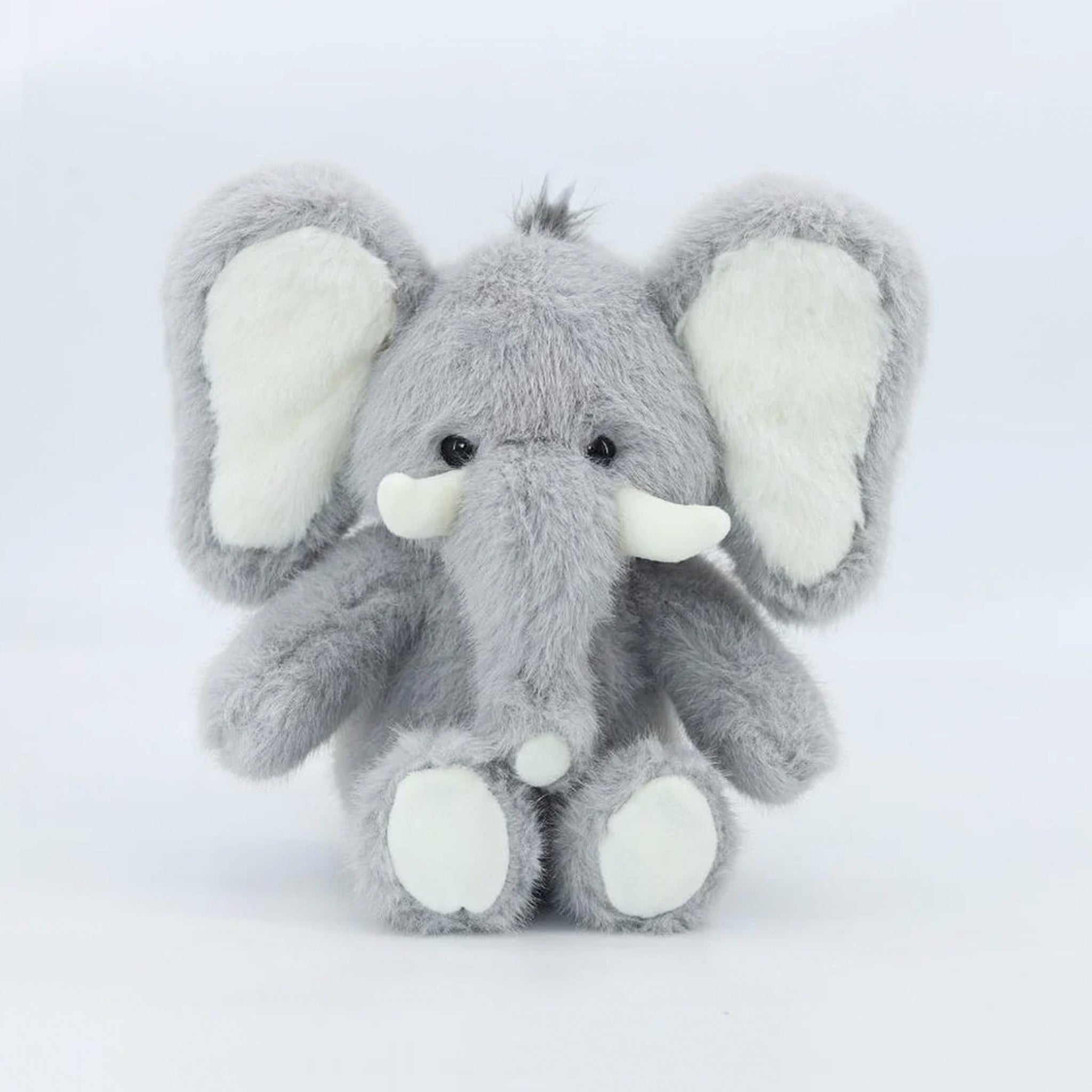 A grey baby elephant shaped stuffed animal. 