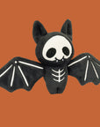 A black bat shaped skeleton stuffed toy.