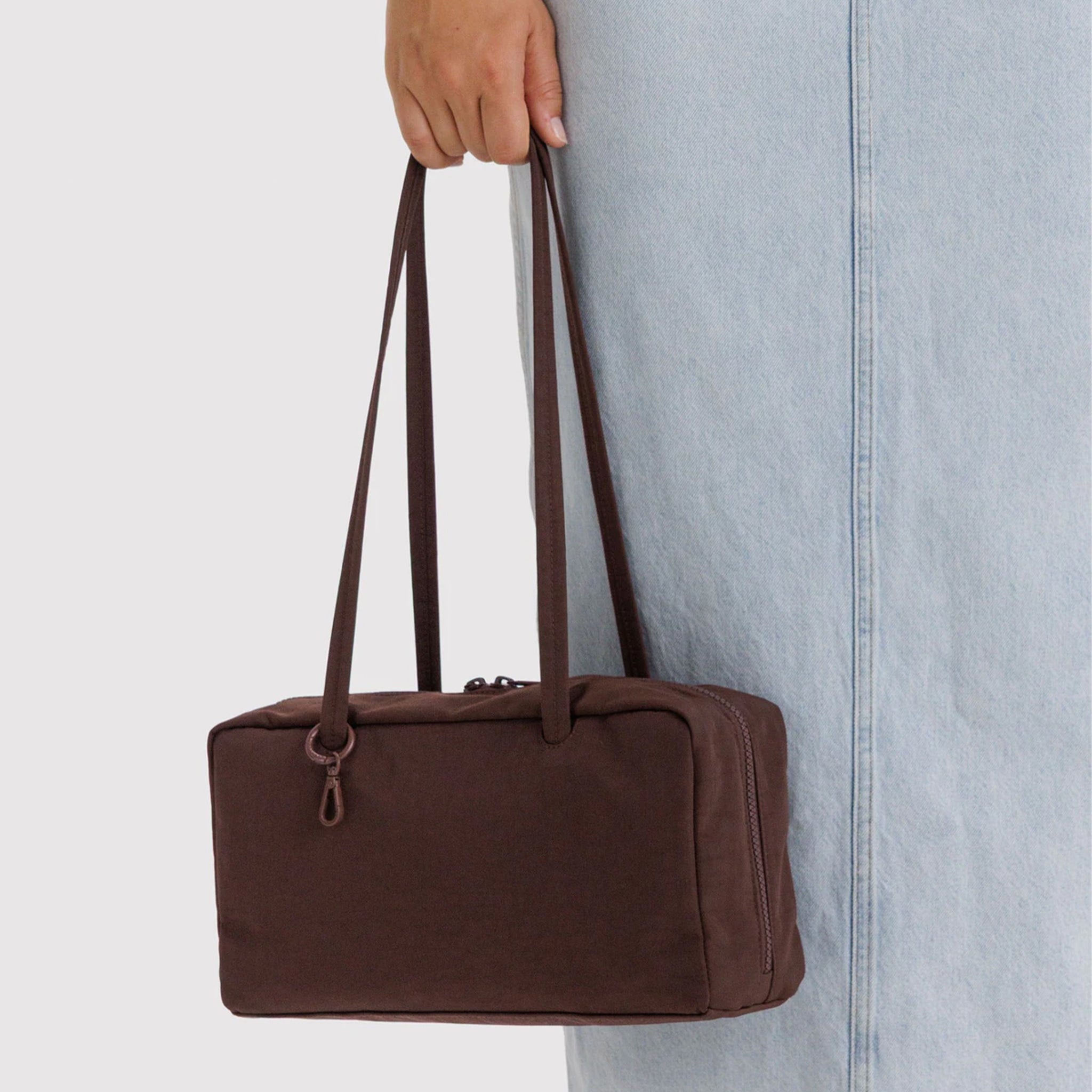 A dark brown nylon rectangle shaped shoulder bag. 