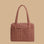 A tan and rust colored printed nylon carry on bag.