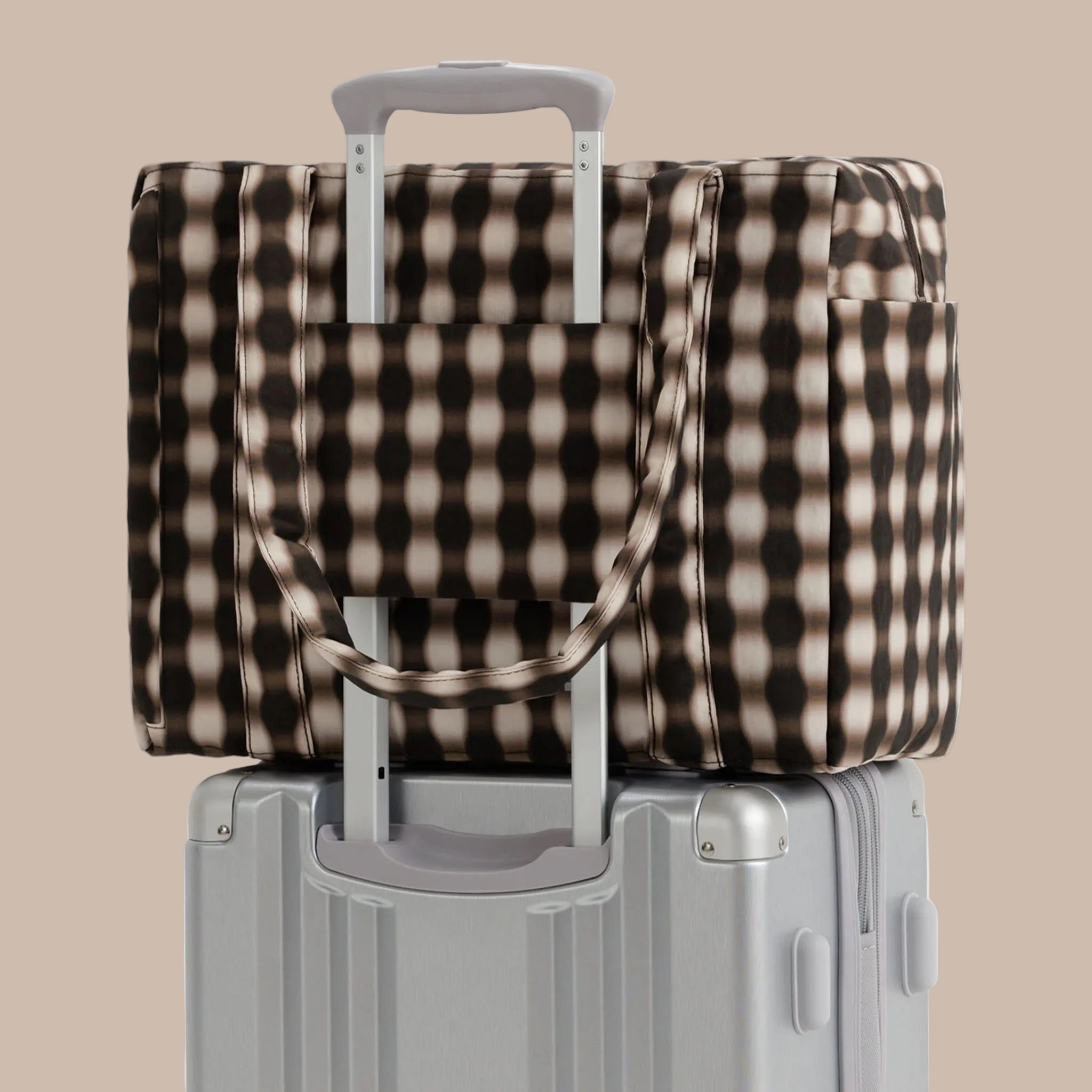 A brown and tan blurred gingham print carry on tote bag. 