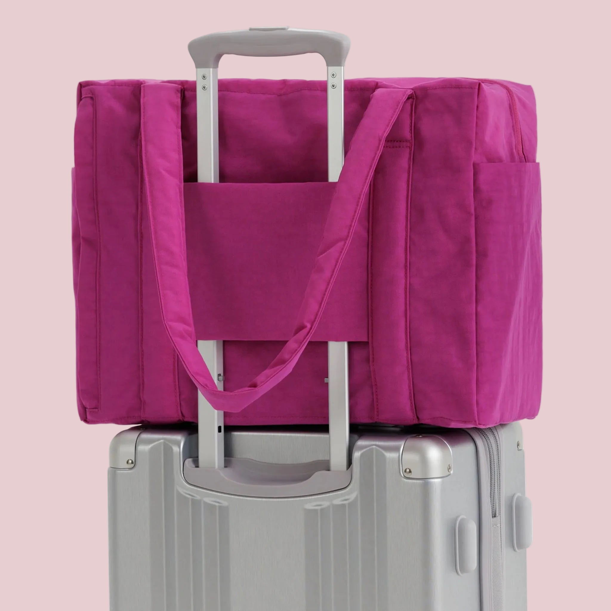 A hot pink nylon carry on tote bag. 