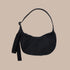 A small crescent shaped nylon shoulder bag with an adjustable strap to make it crossbody.