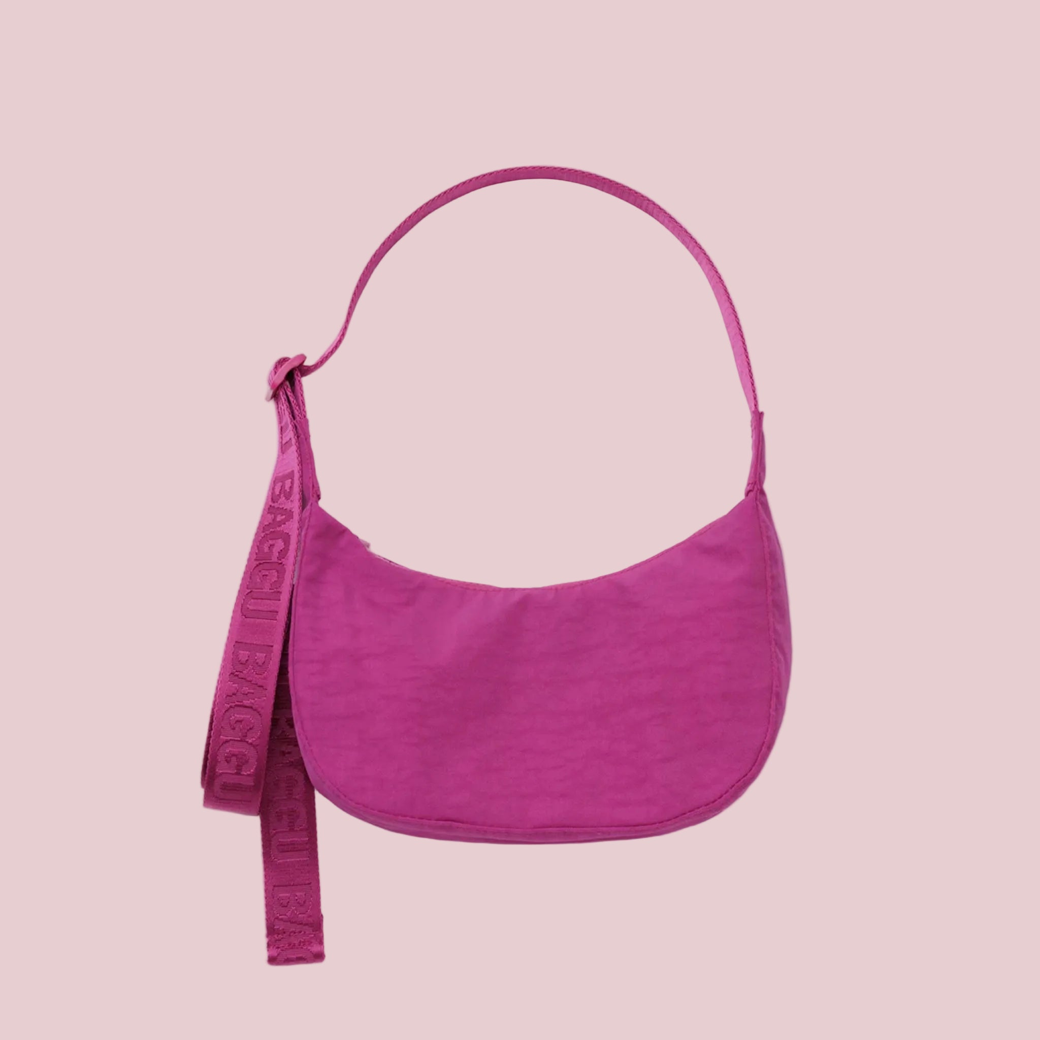 A hot pink crescent shaped nylon handbag. 