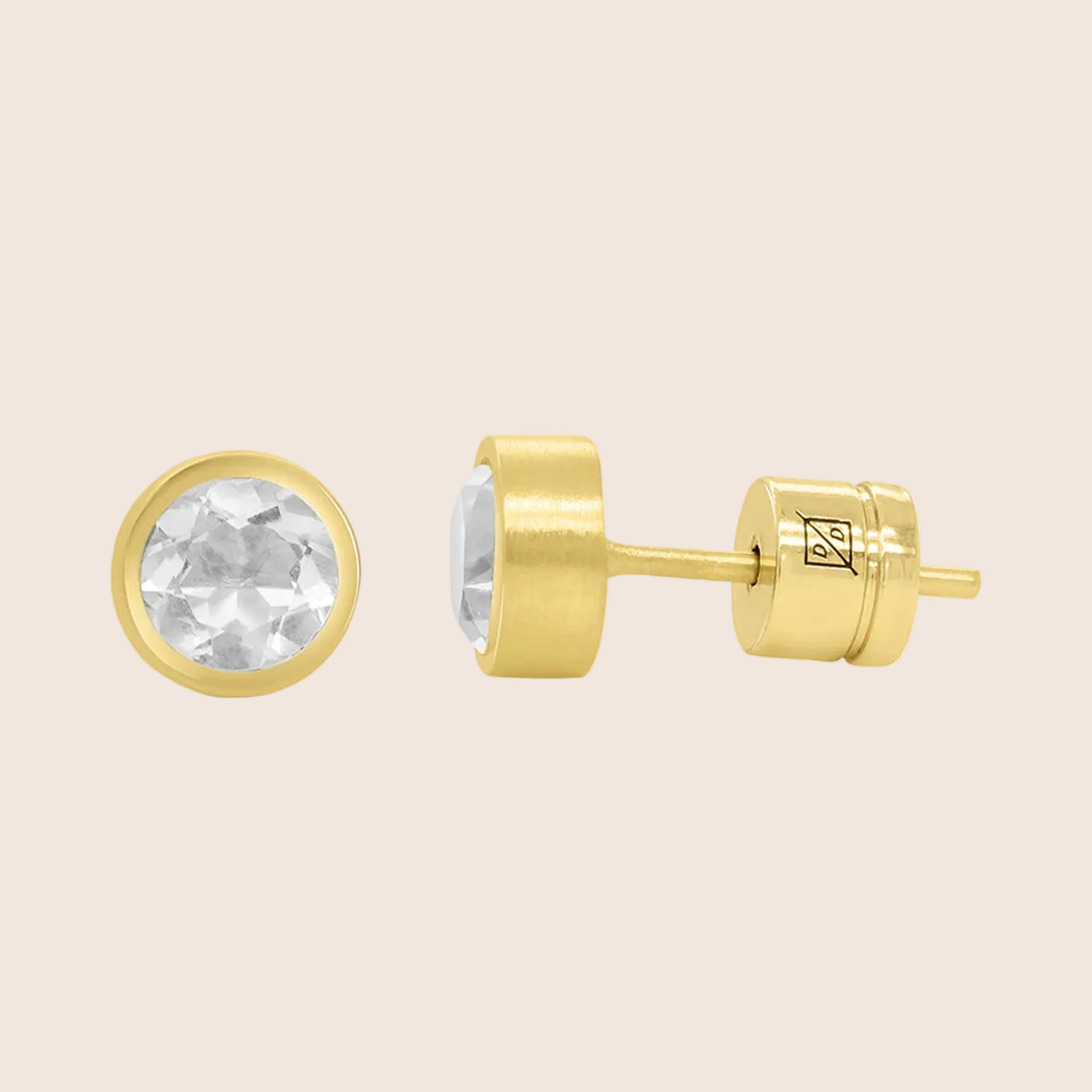 A pair of gold circle stud earrings with crystal cz stones in the center. 
