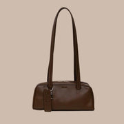 A small recycled brown leather handbag with shoulder straps. 
