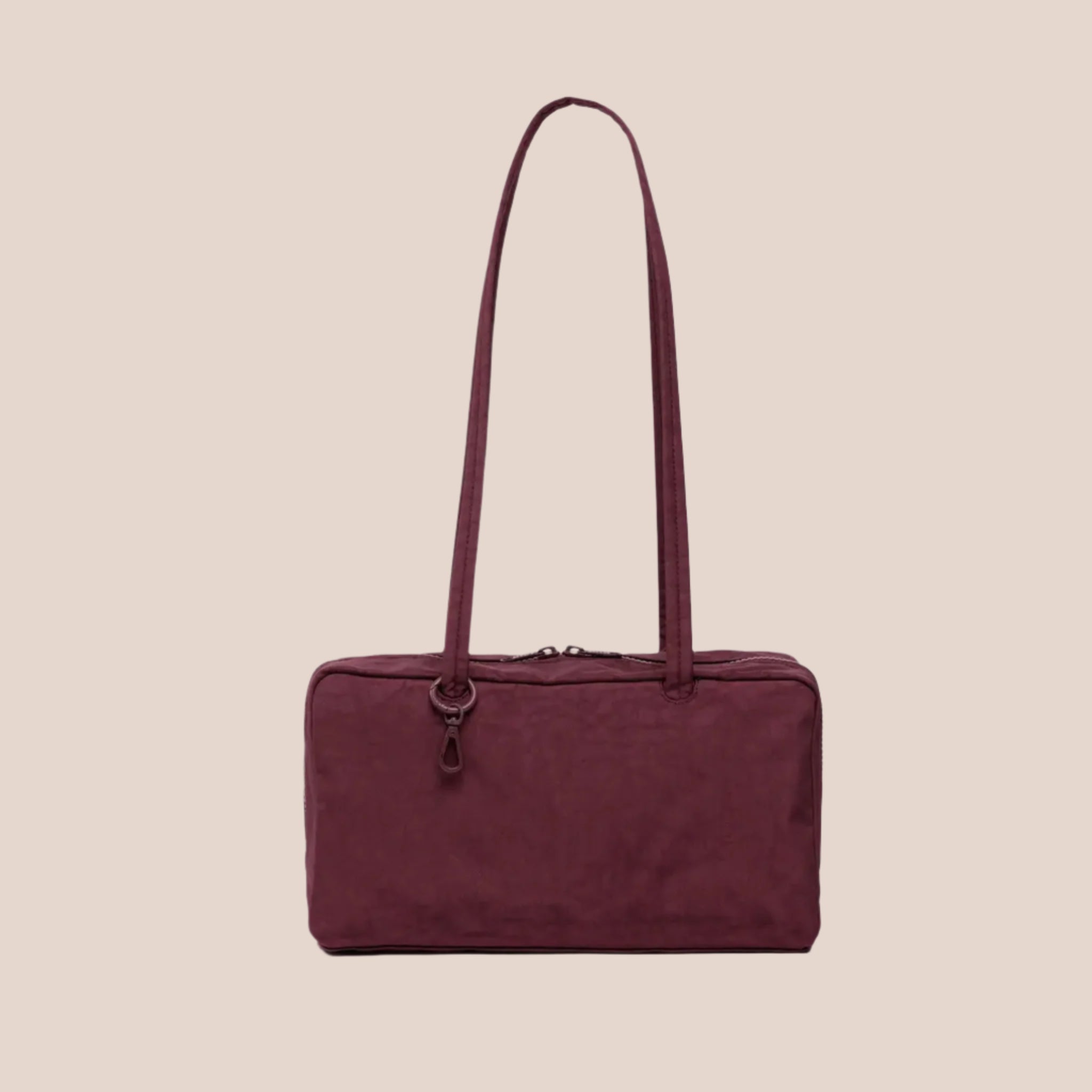 A mahogany reddish brown colored nylon handbag with a large shoulder strap. 