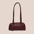 A burgundy recycled leather small handbag with shoulder straps. 