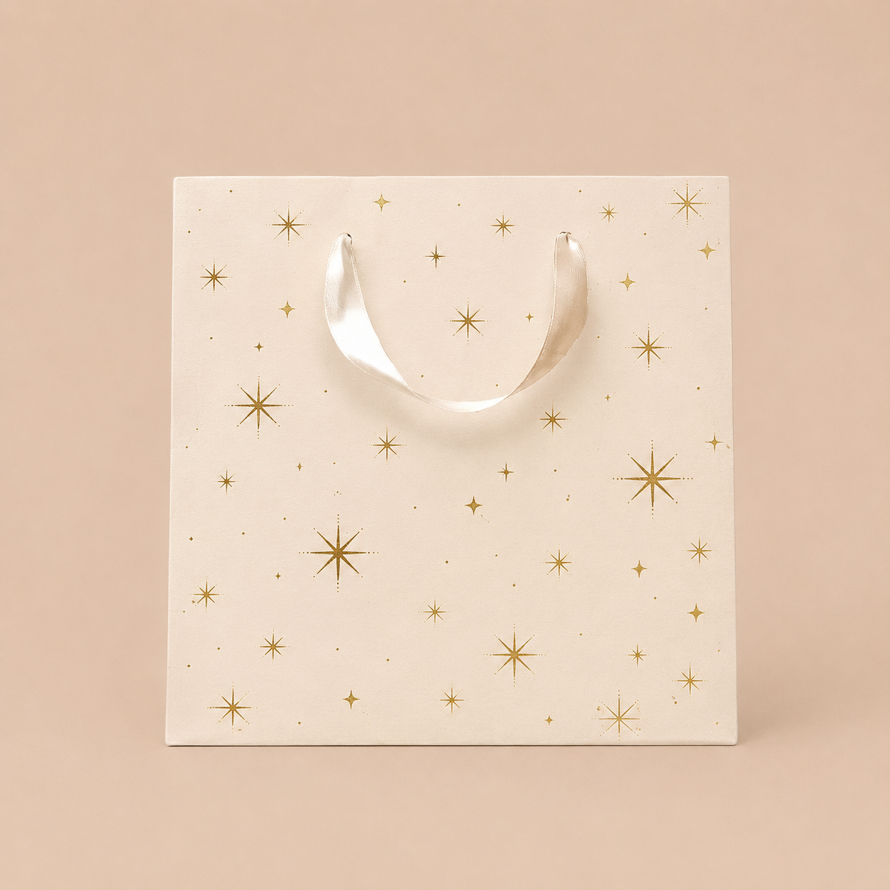 On an ivory background is a light pink gift bag with gold star details.