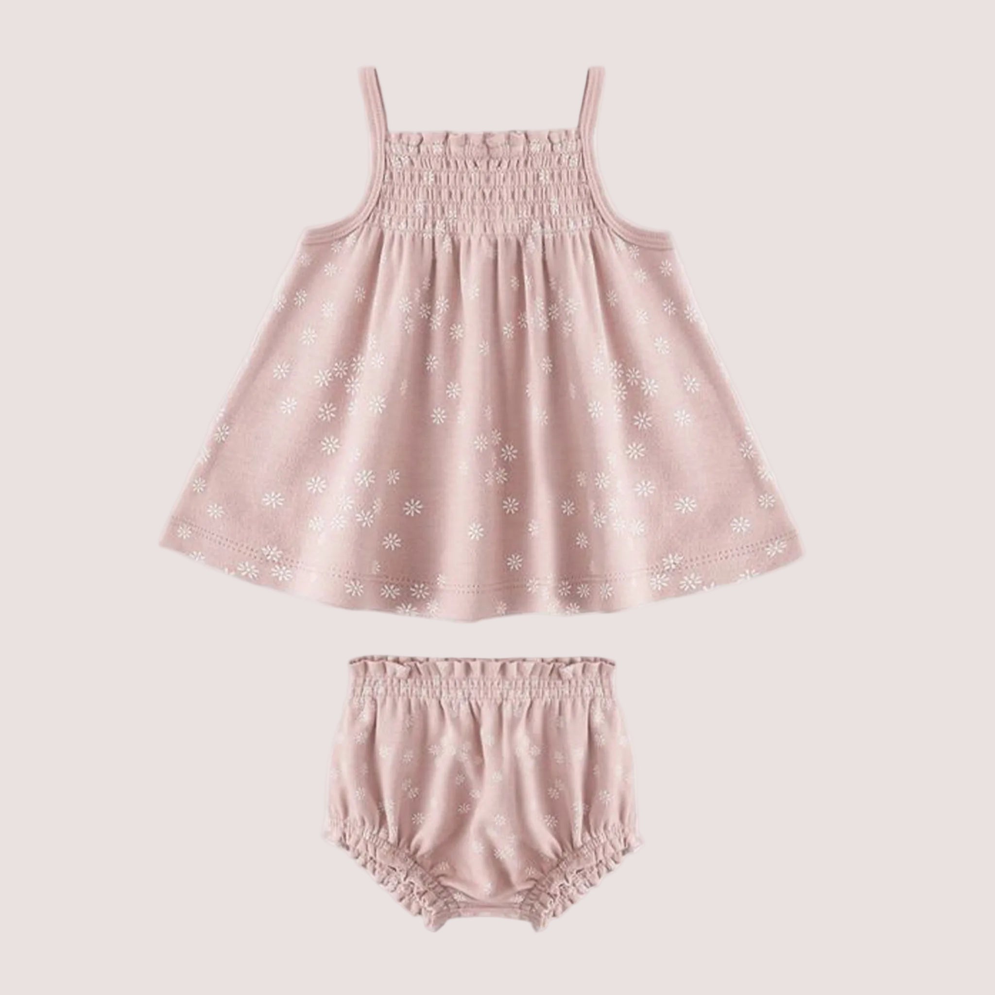 A light pink tank top and bloomer set with a white daisy print. 