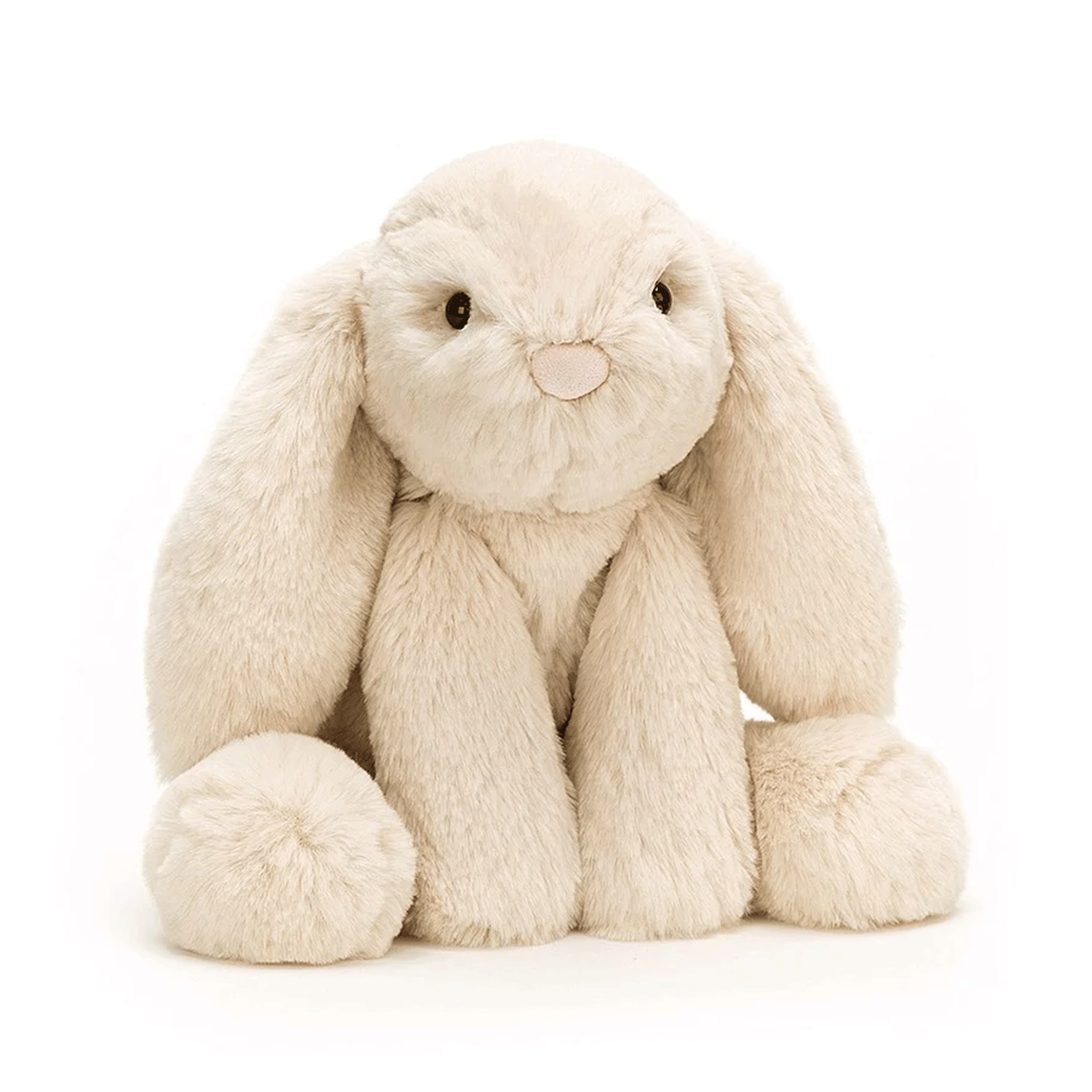 On a white background is a tan / ivory bunny stuffed animal with floppy ears and a fluffy tail. 