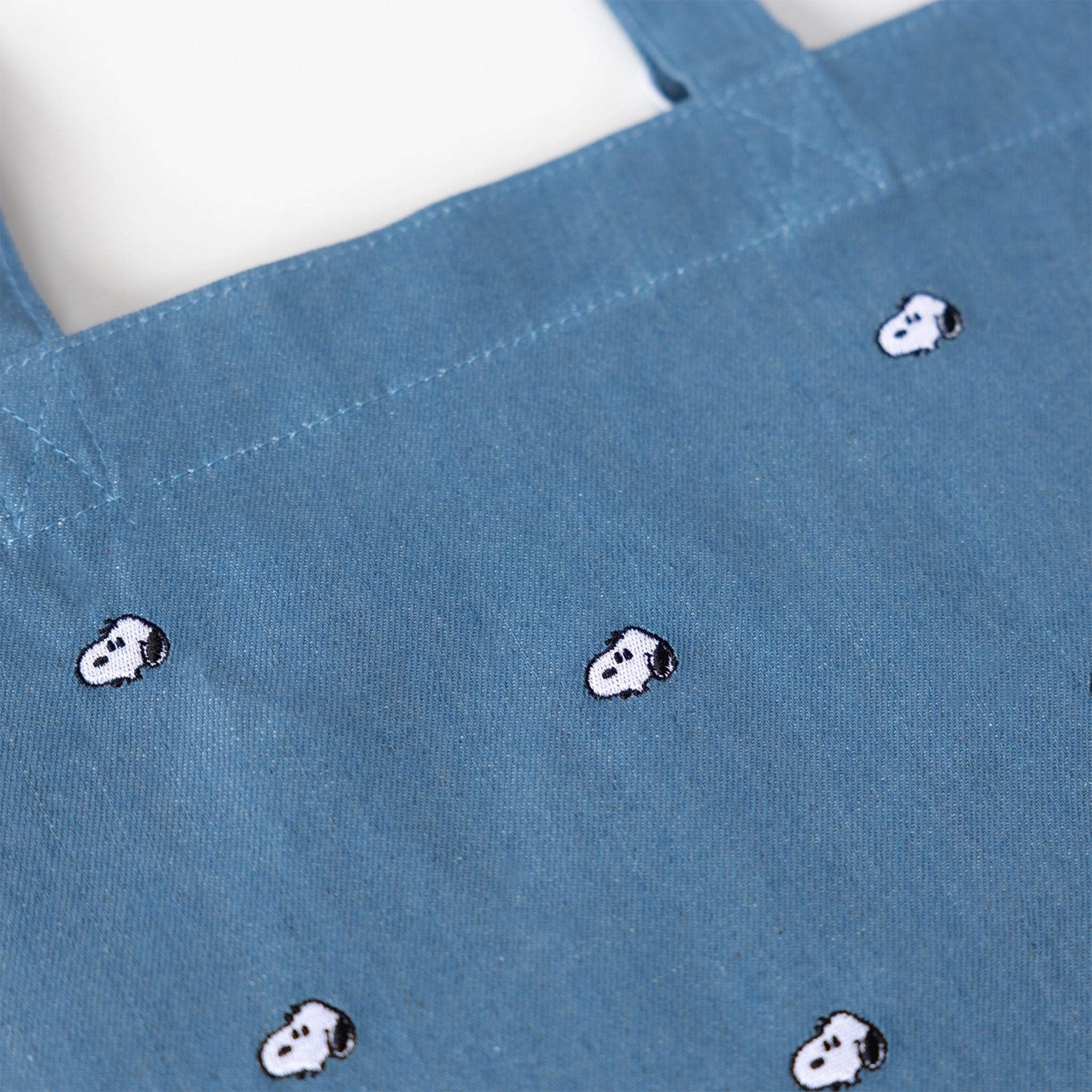 blue denim tote bag with a Snoopy embroidered pattern. 